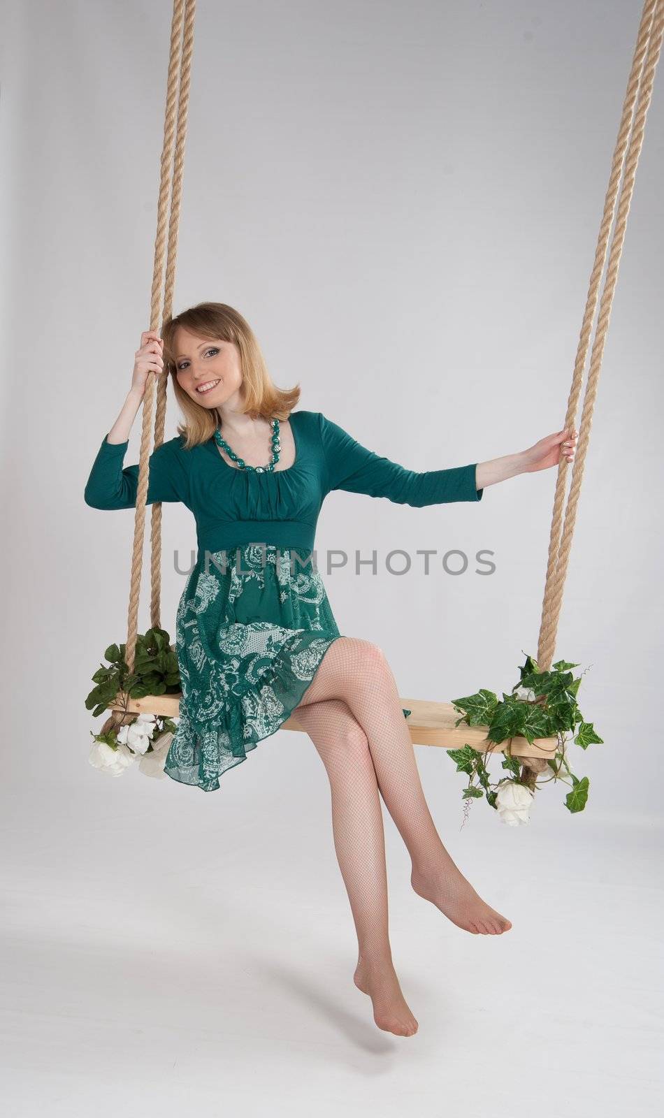 beautiful woman in a green dress on a swing