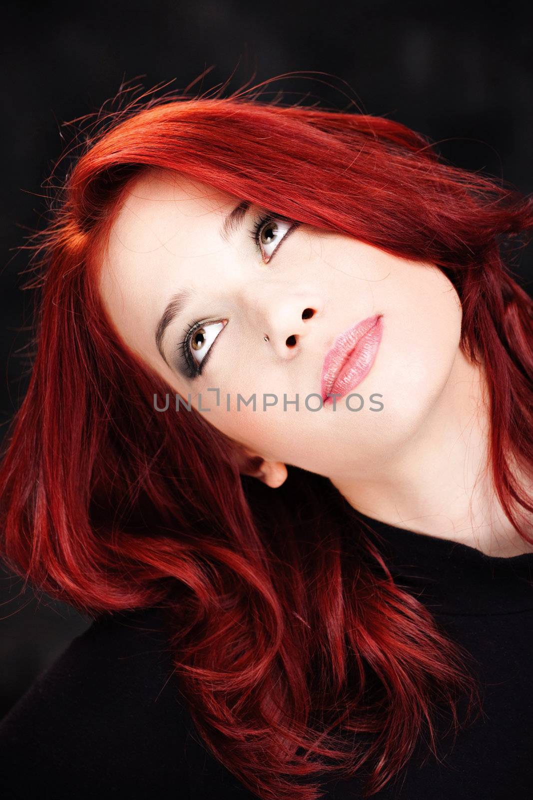 Red hair woman looking up on dark background