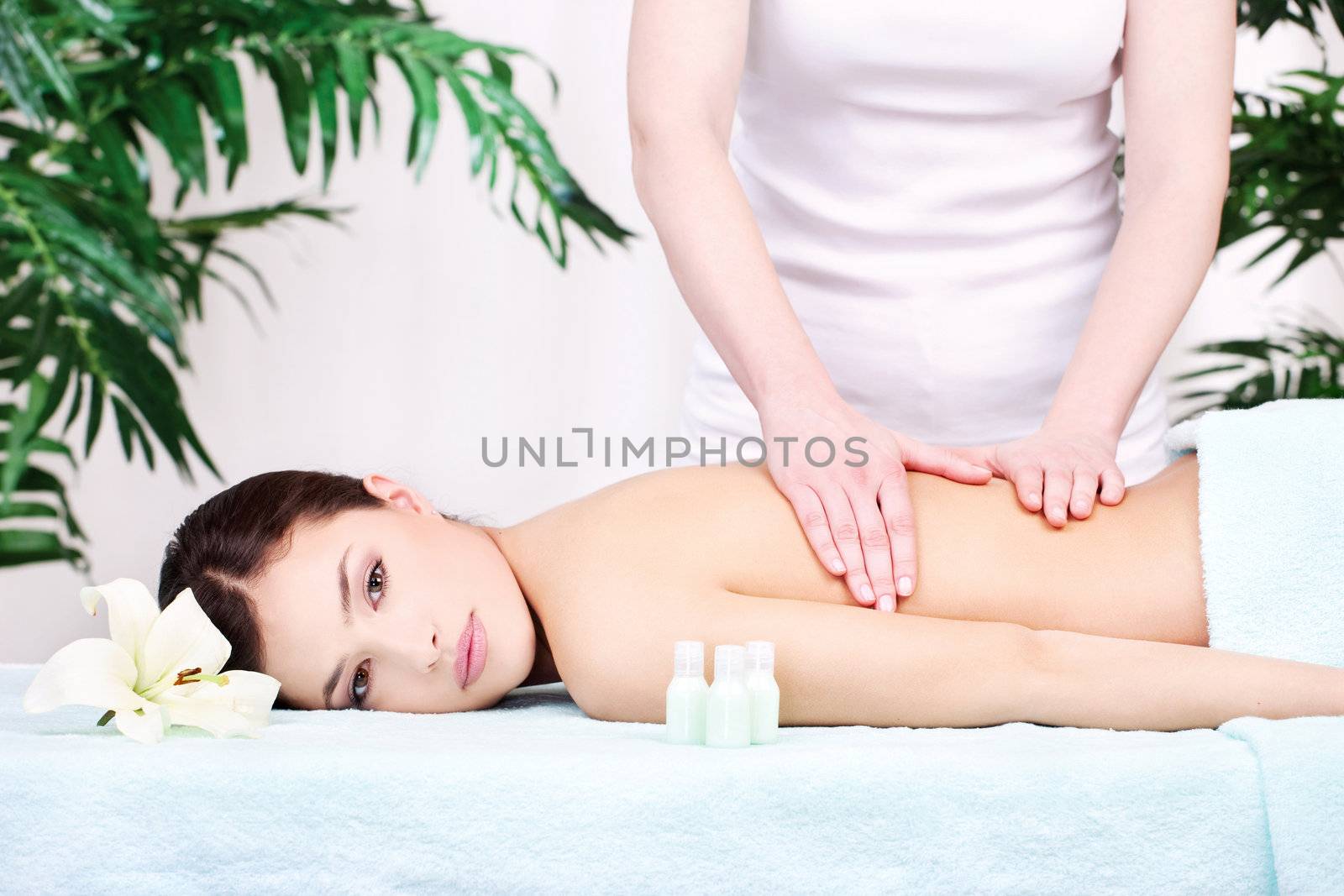 Pretty woman on back massage in spa center