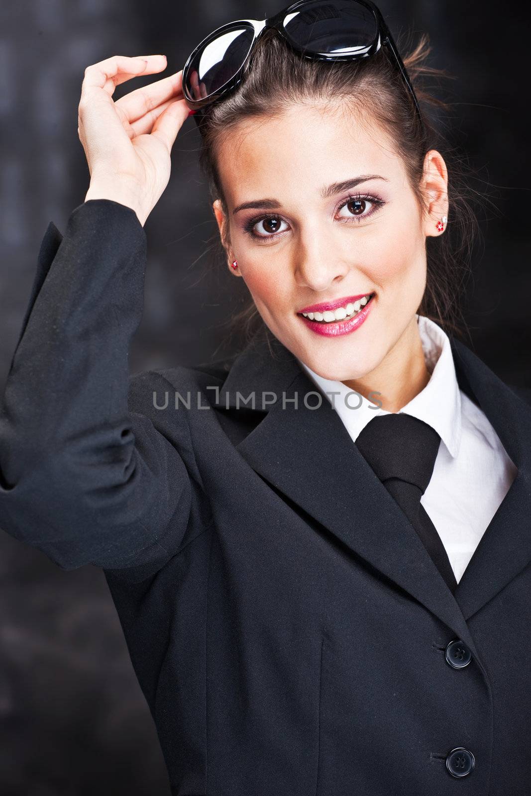 Pretty woman with sun glasses on dark background