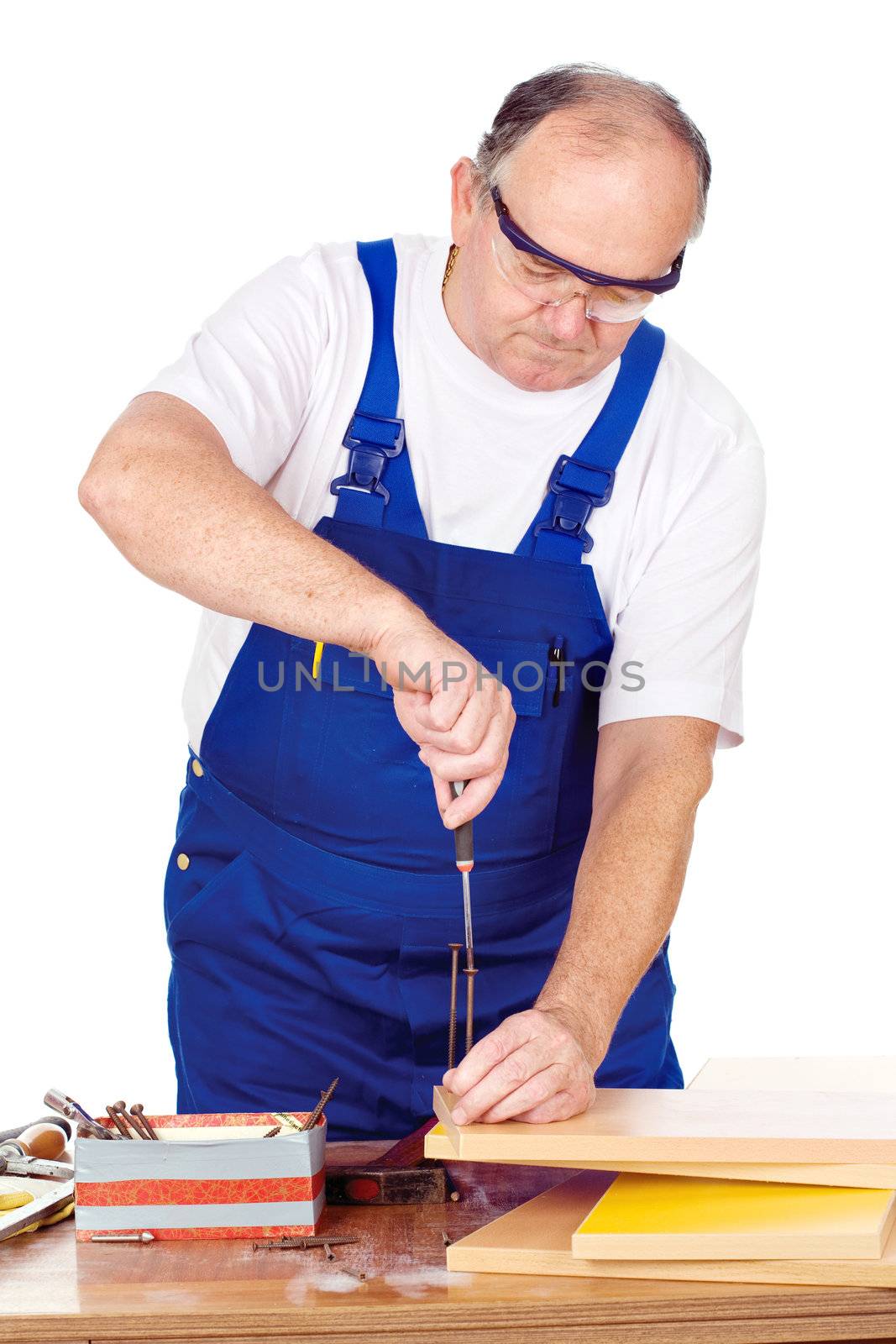 Middle age worker screwing nail in panel board, isolated on white background