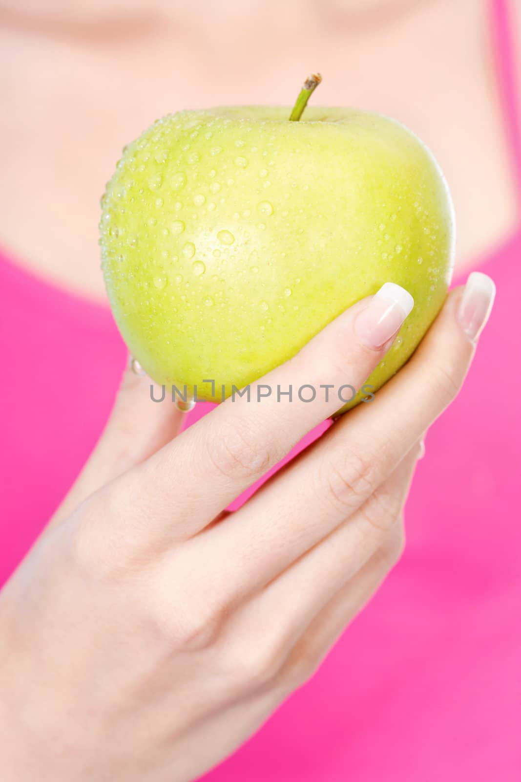woman's hand holding wet apple