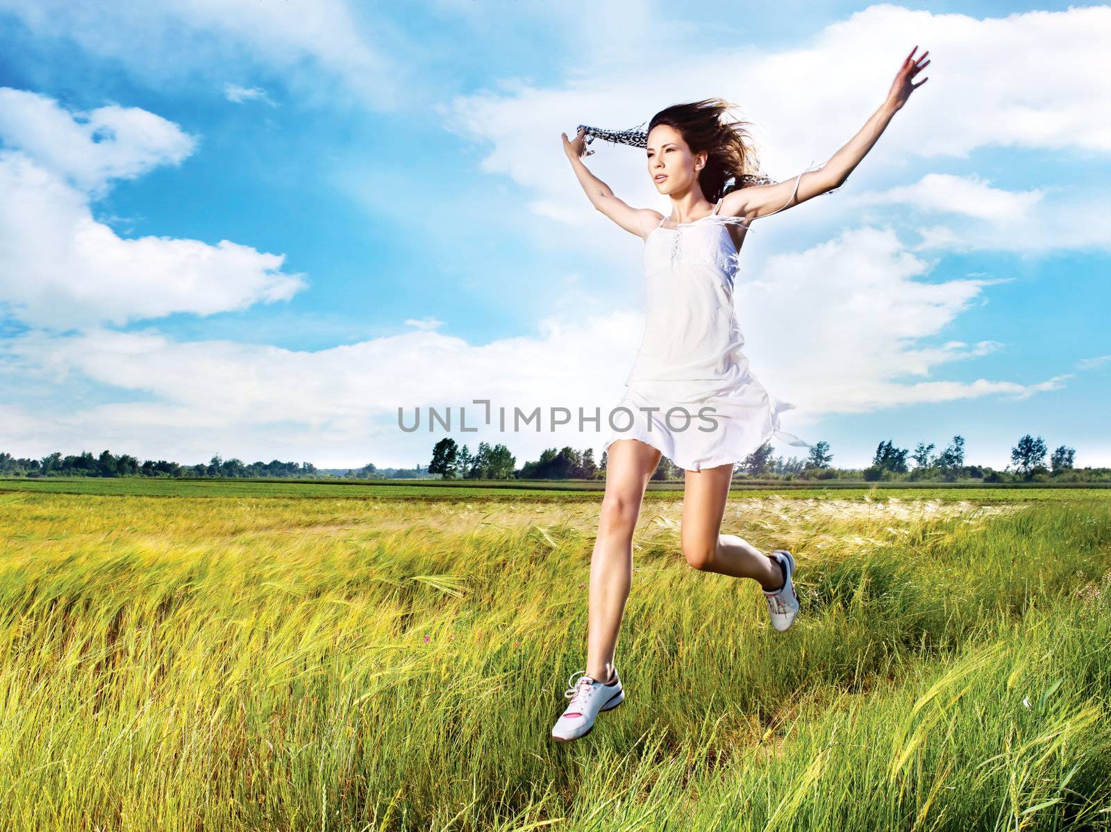 woman running across field by imarin