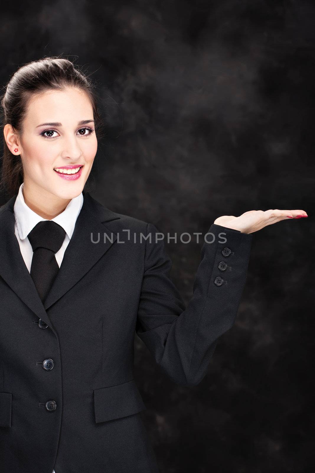 Pretty smiled business woman holding hand as a place for designer to put something on