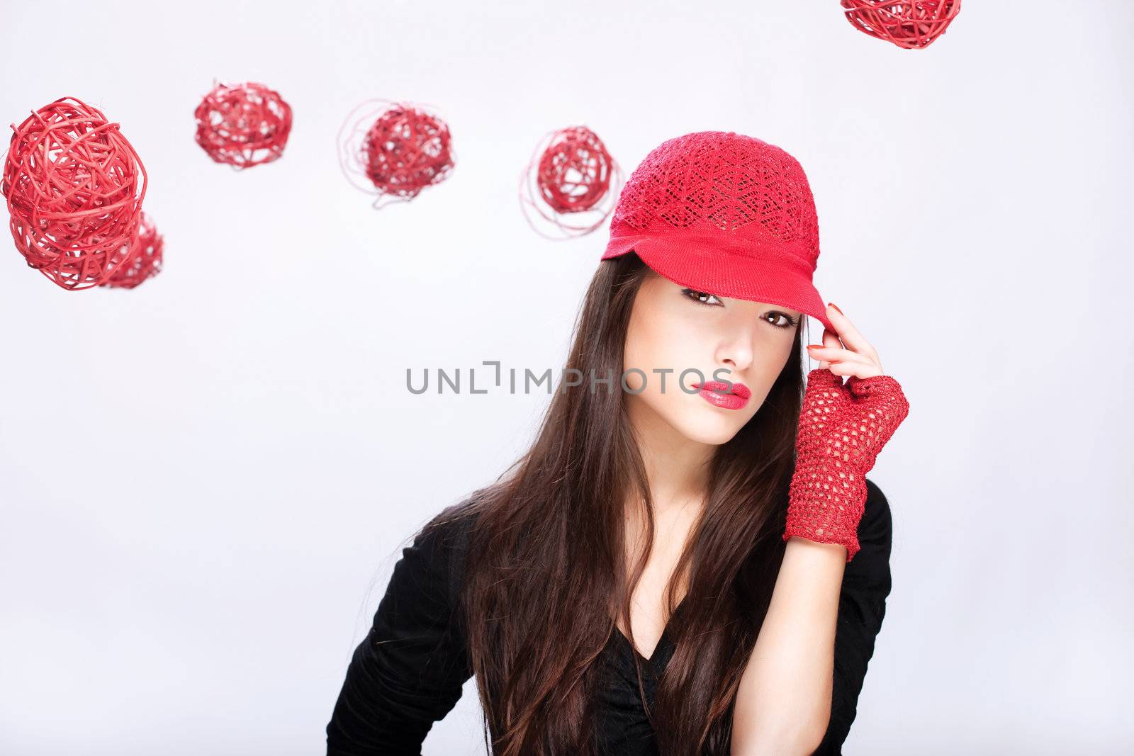 Pretty woman with red hat between red balls