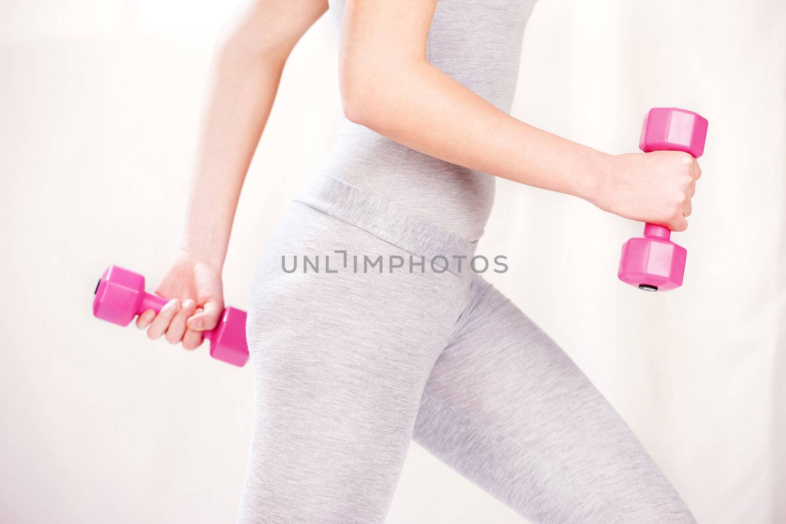 Female body doing fitness exercises with two weights