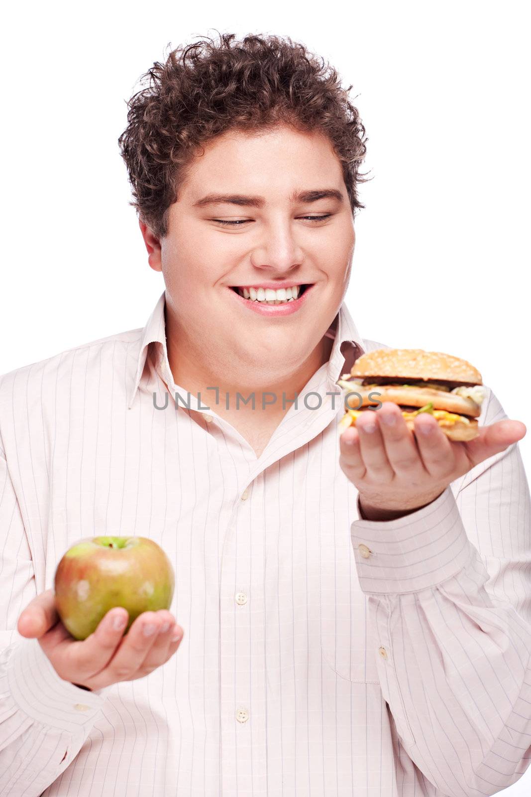 Young chubby man holding apple and hamburger, isolated on white