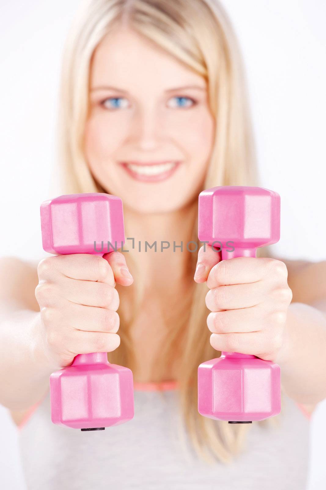 Young woman with two weights doing fitness exercises, focus on weights