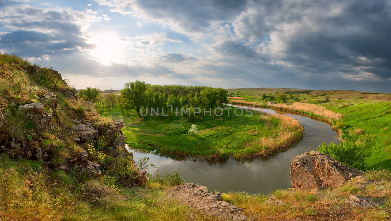 View from the mountain on the river, the wood and a meadow, shined with a bright sun