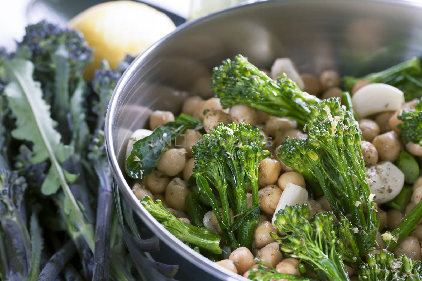 Broccoli, chickpeas and garlic tossed in oil and ready for cooking.