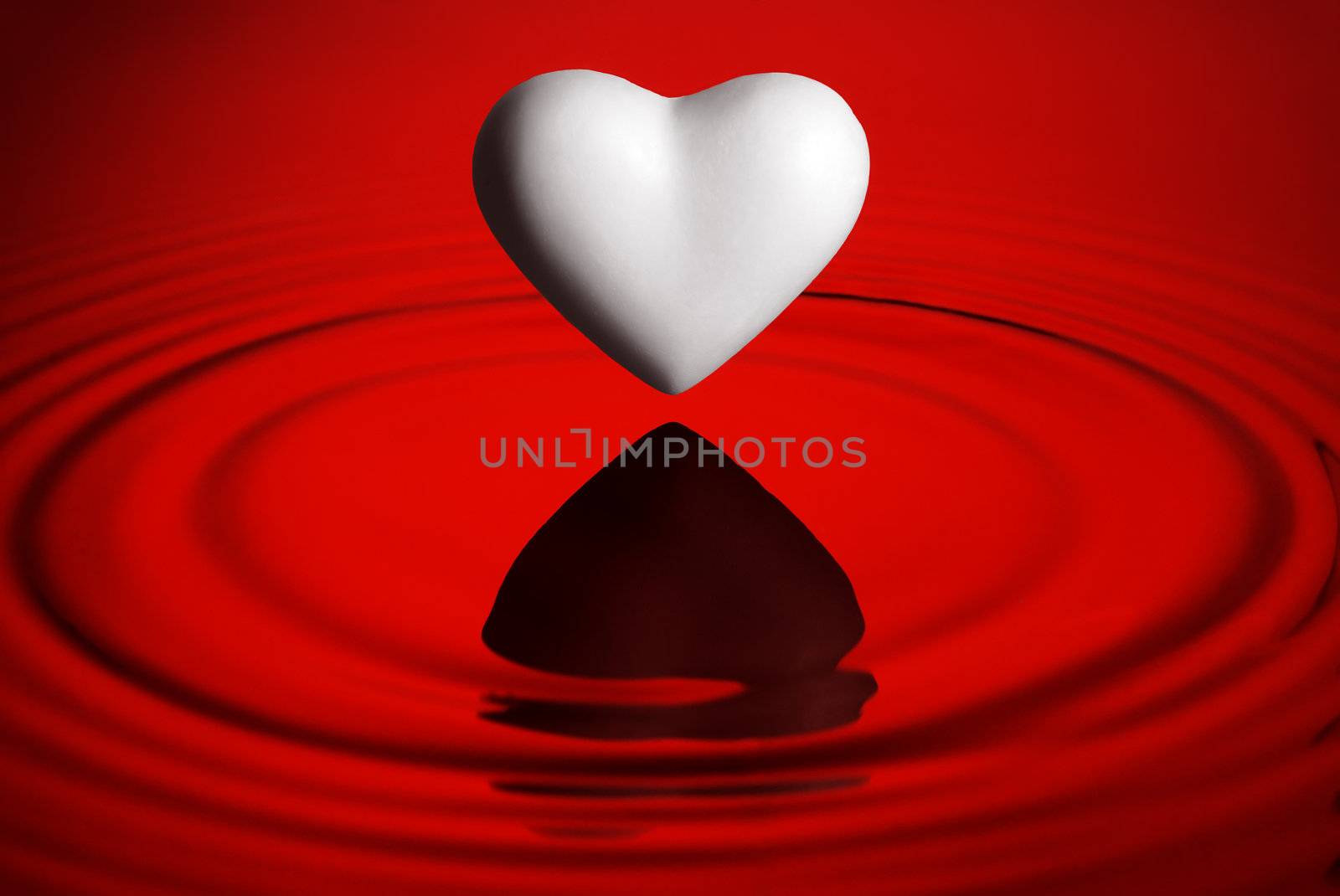 White heart over red water ripples background