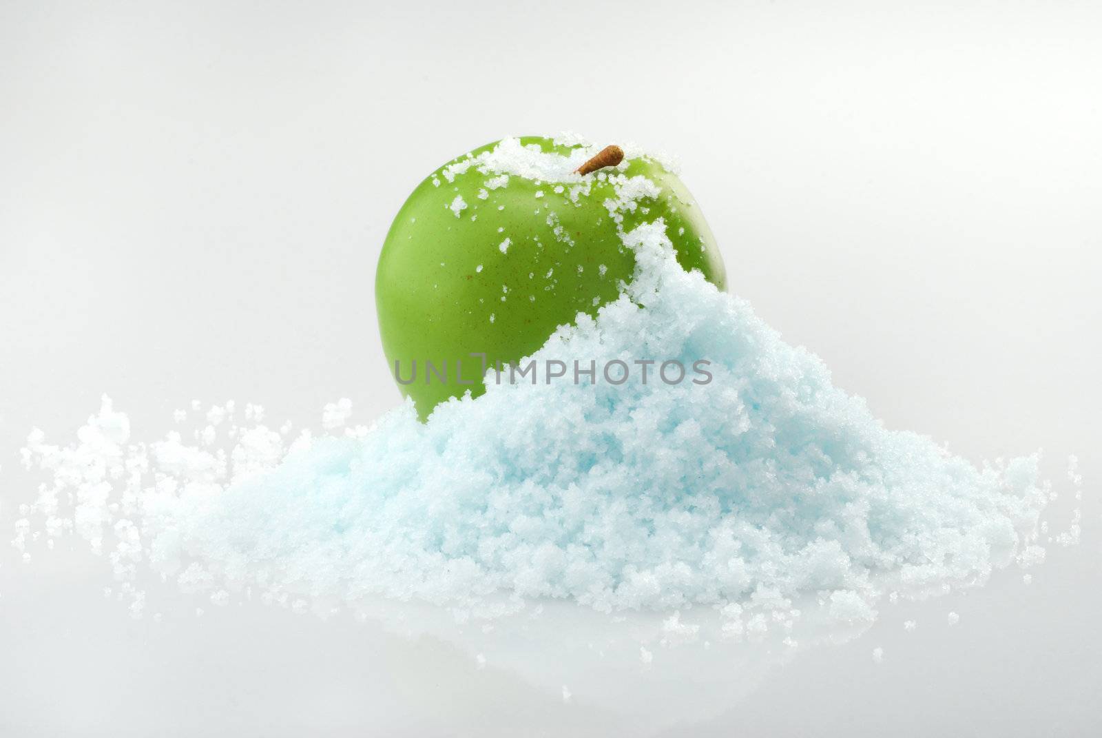 Green delicious Christmas apple in snow with white background