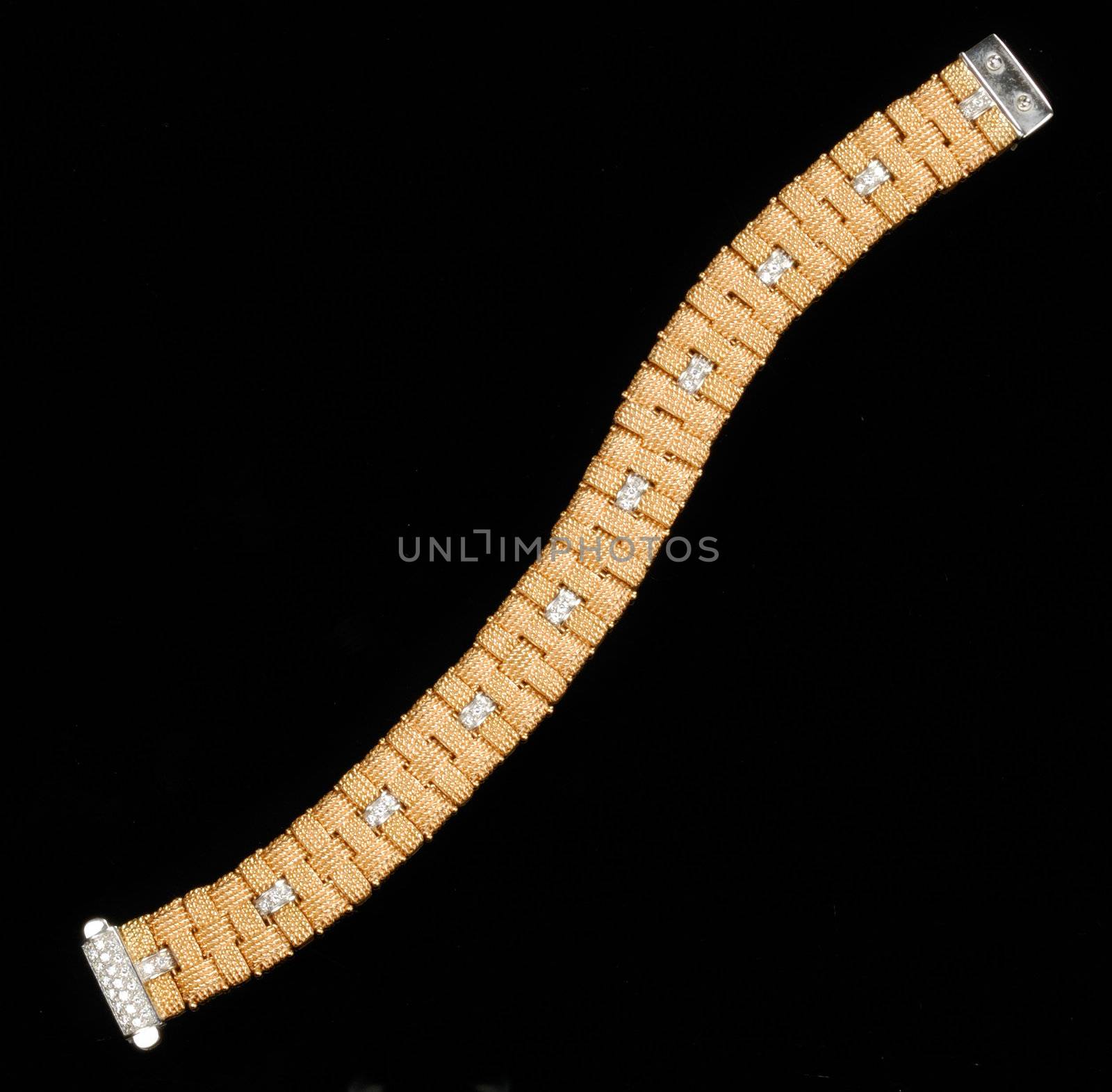 Golden bracelet with diamonds over black background