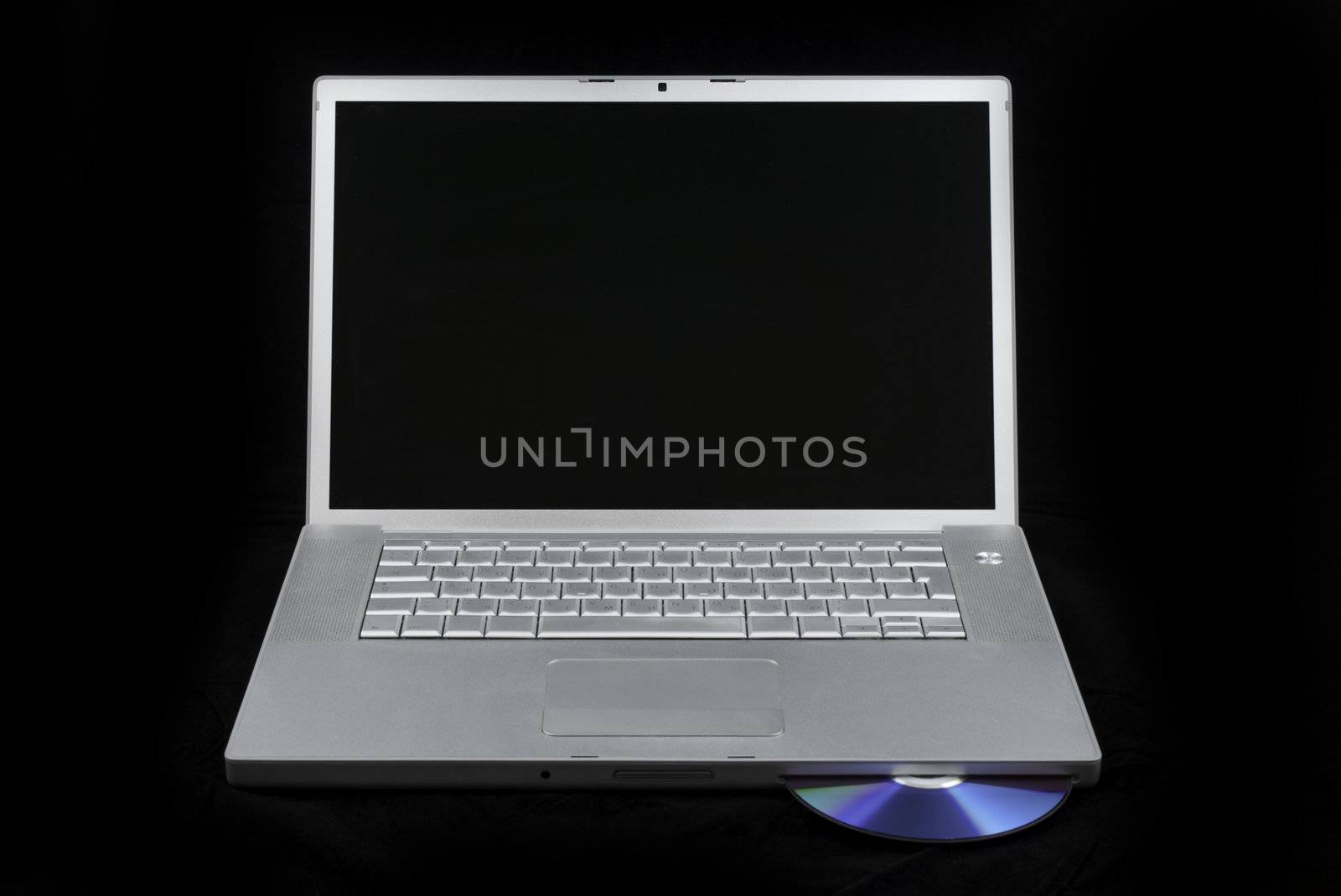 Silver portable computer with CD inserted. Front view.