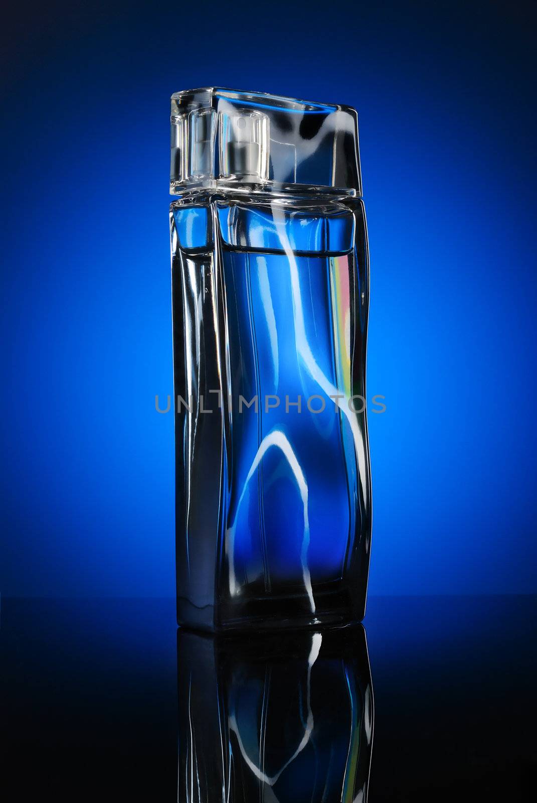 Designer’s bottle of a man perfume with reflection on blue background