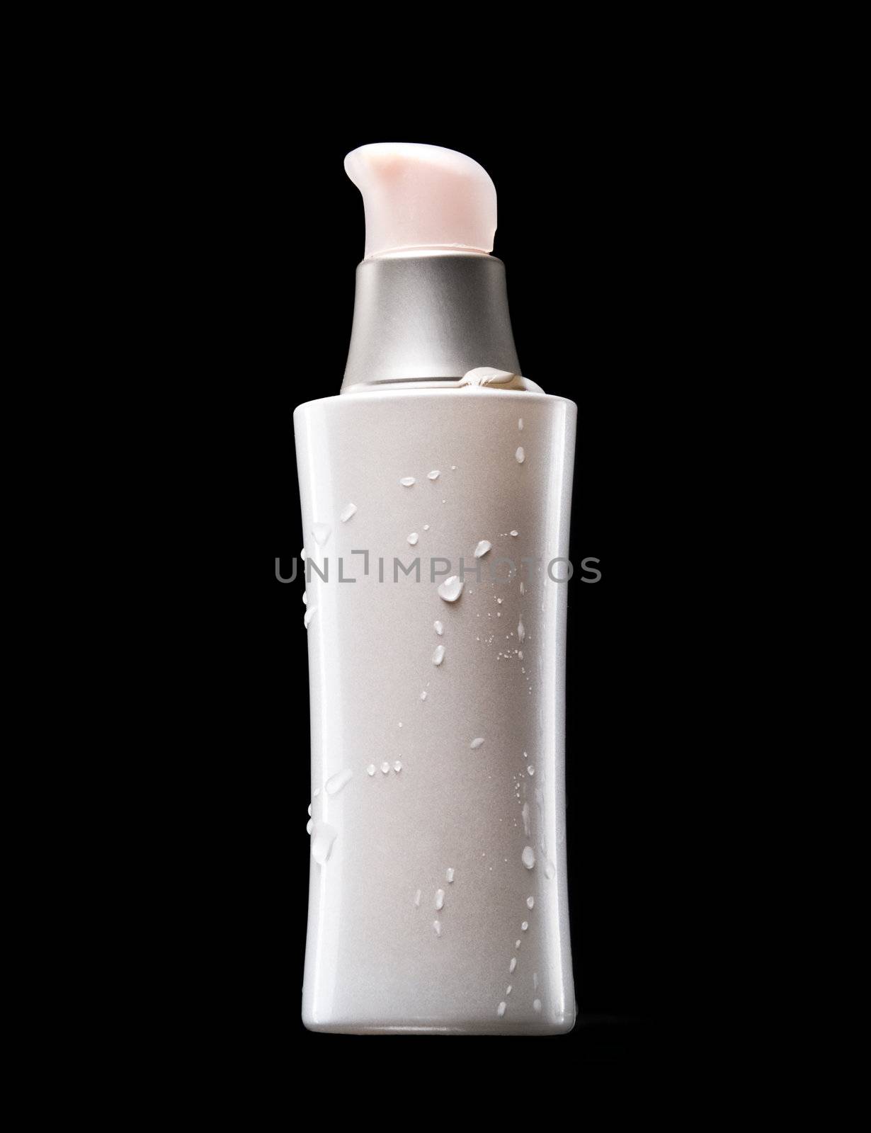 White bottle of cometics with pink covers and water drops on a black background