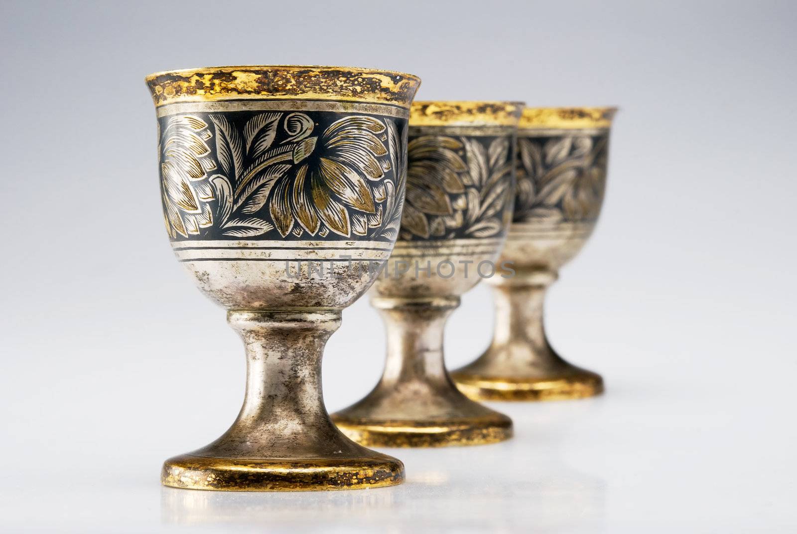 Three ancient wine cup in a line isolated over white background