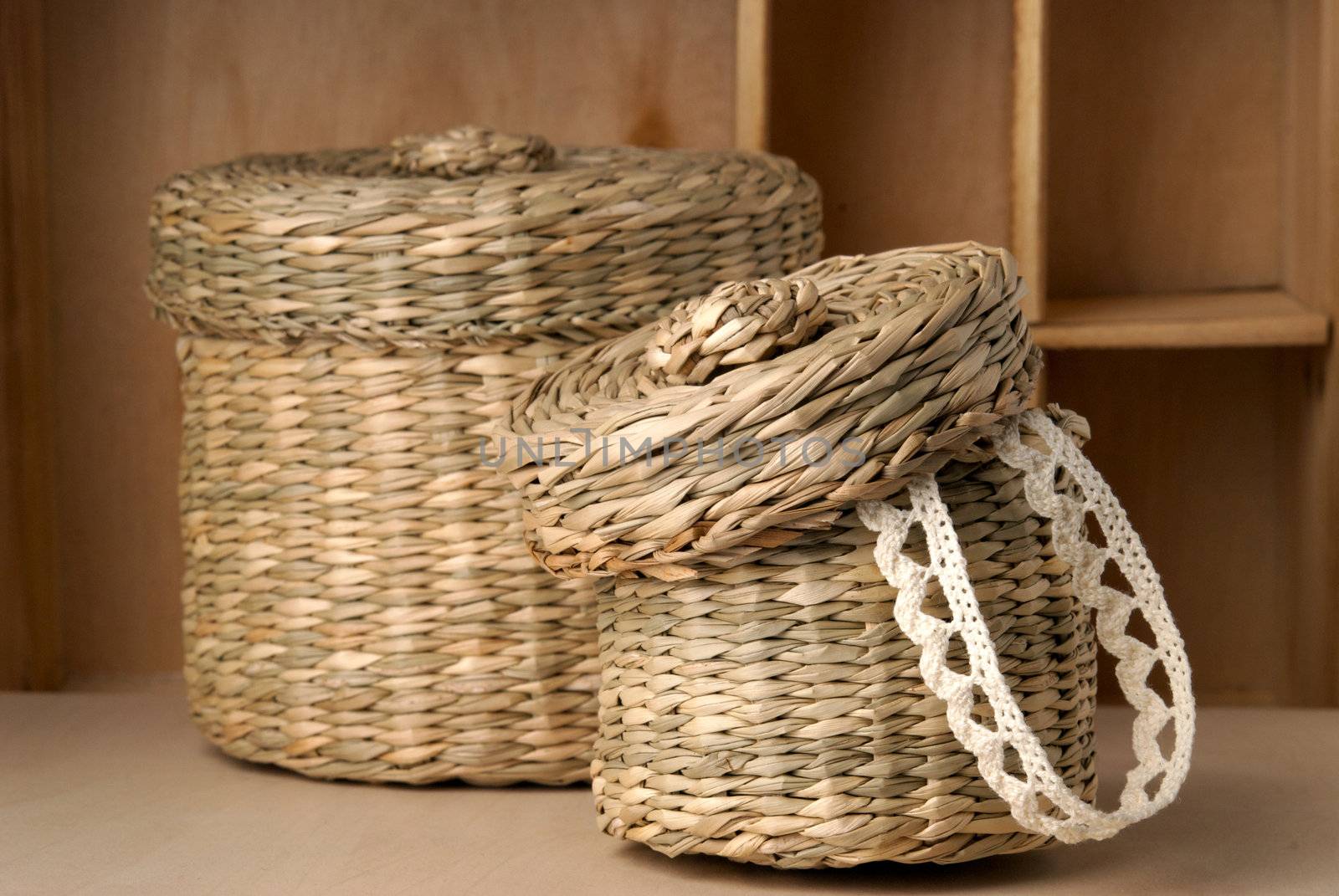 Two wattled baskets with lace closeup isolated on wooden background