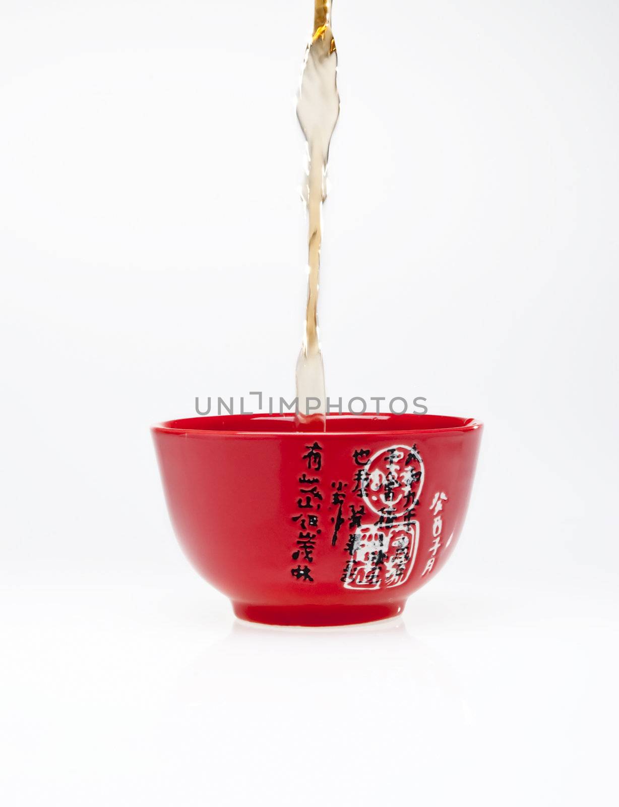 Pouring tea into chinese red teacup