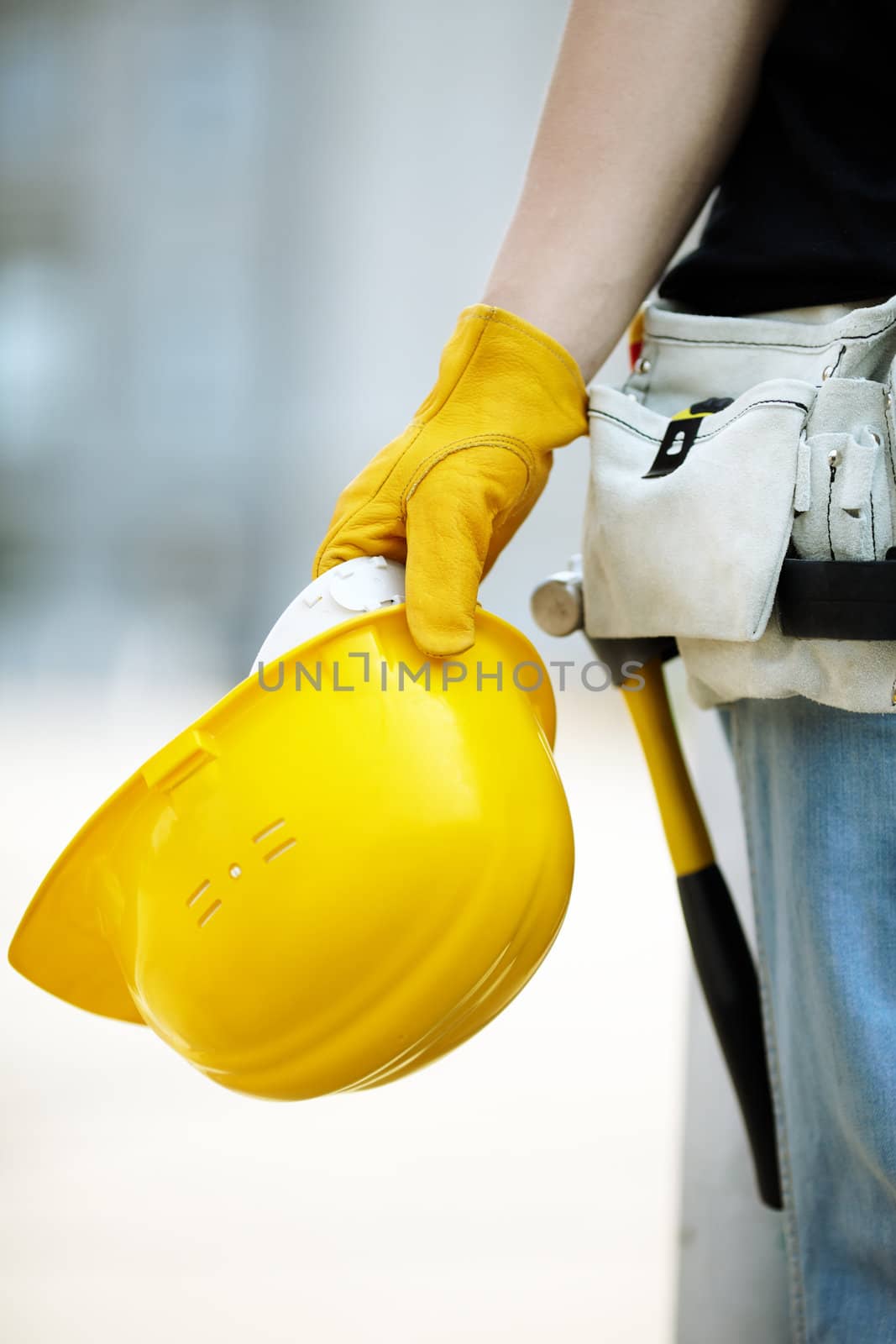 builder with yellow helmet and working gloves on building site