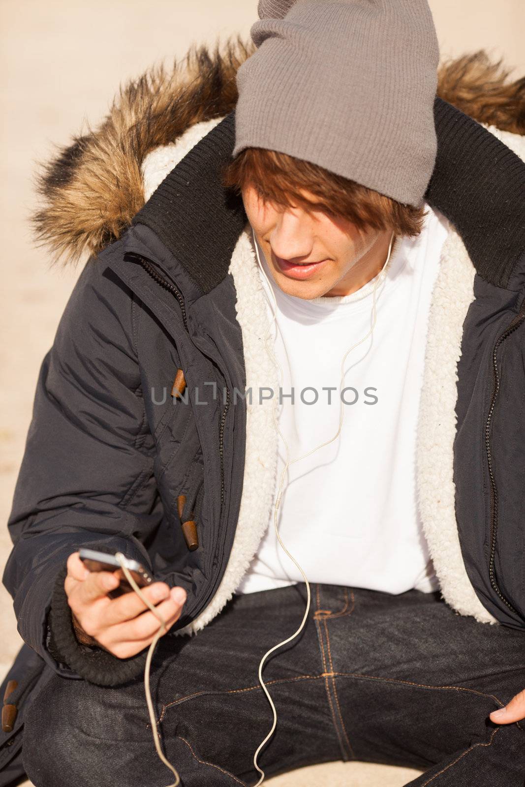 young handsome man consulting phone outdoors by Lcrespi