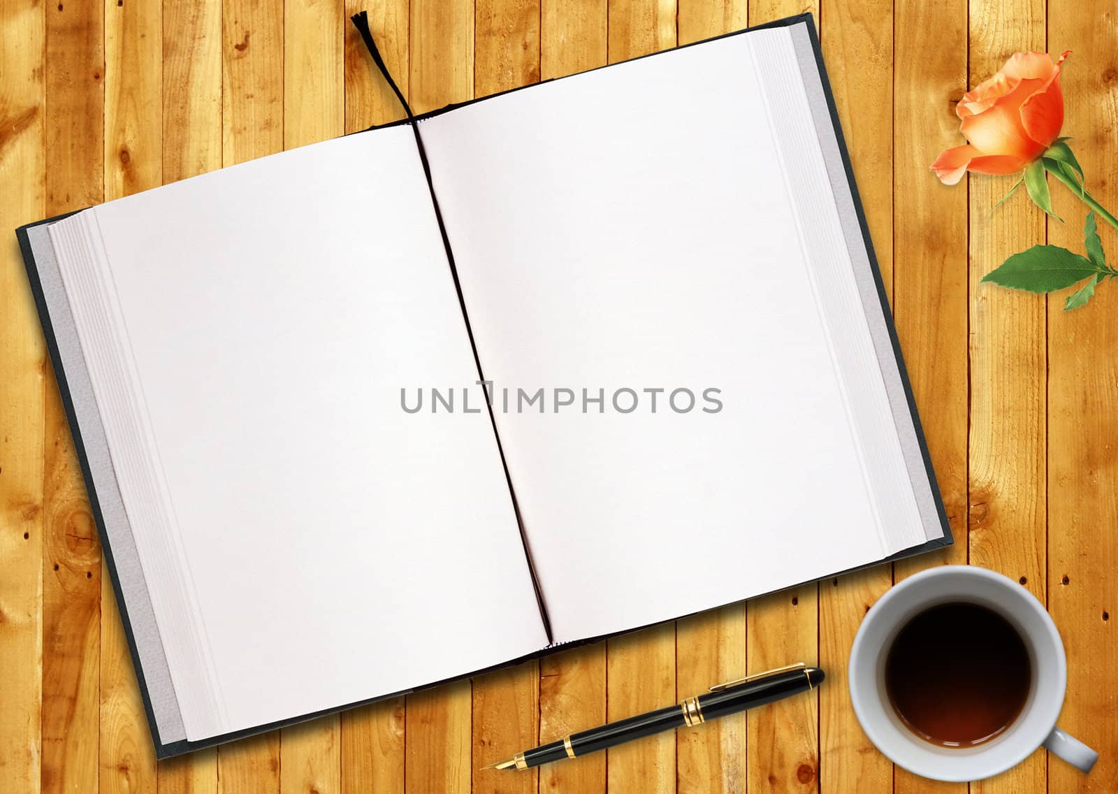 blank opened book outdoors on wooden disk Pen, flower and cup of tea.