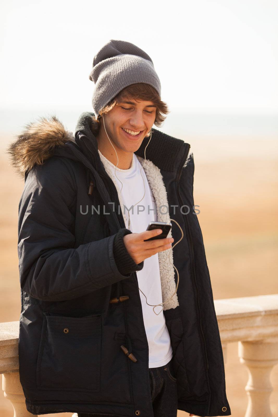 young handsome man consulting phone outdoors by Lcrespi