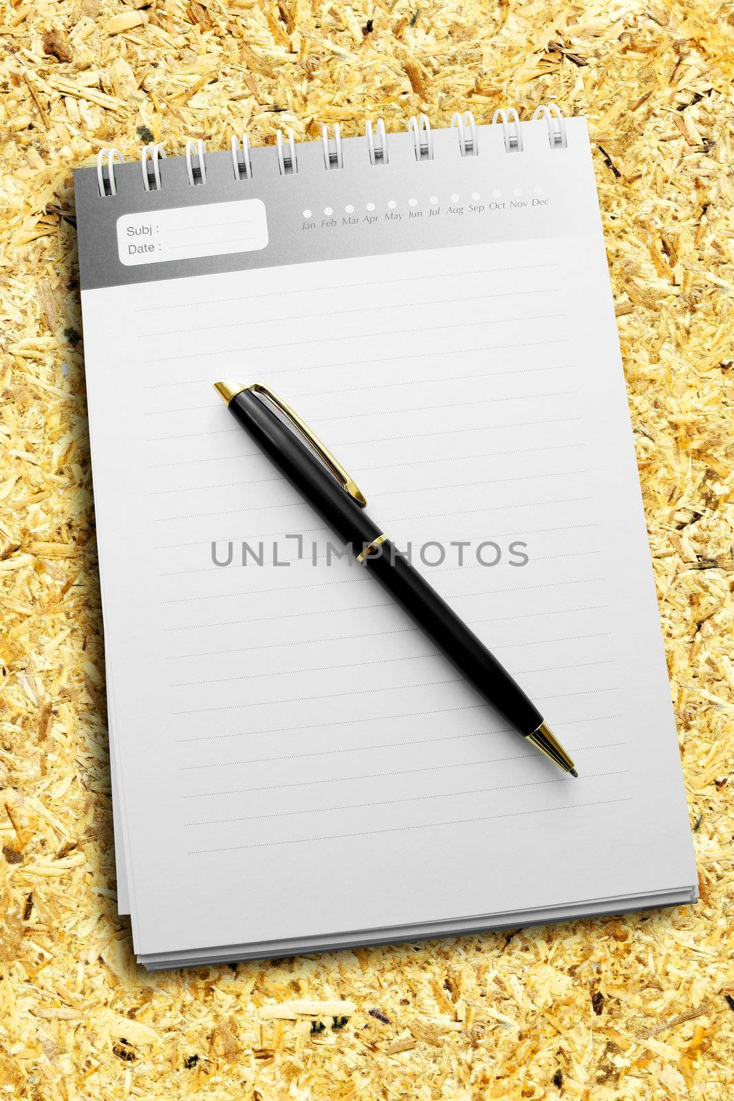 A pen on a diary with striped paper and all on the recycle compressed wood.