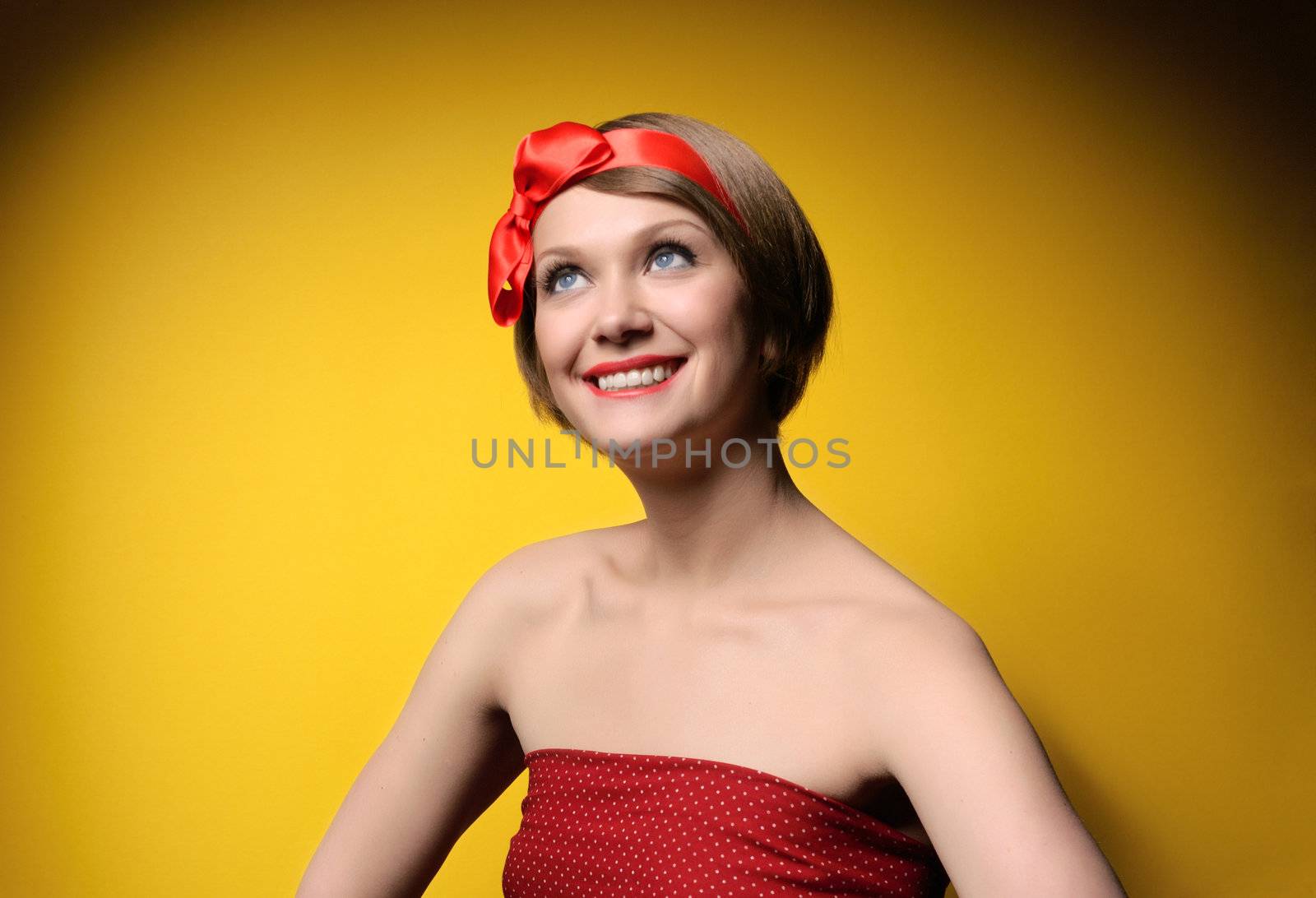 Close-up portrait of smiling beautiful young girl in retro style. Isolated on yellow background