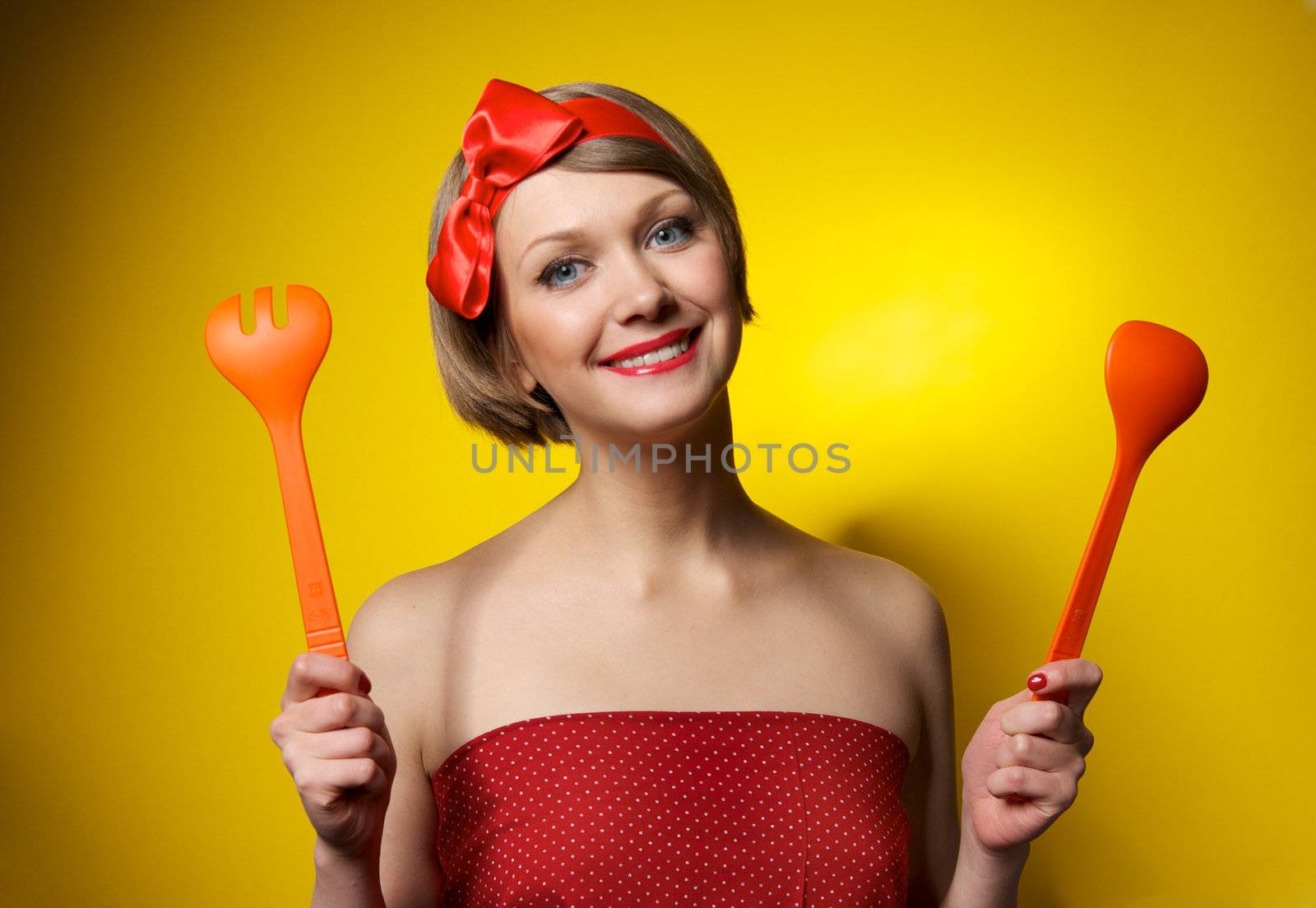 Beautiful pinup style housewife with kitchen utensils