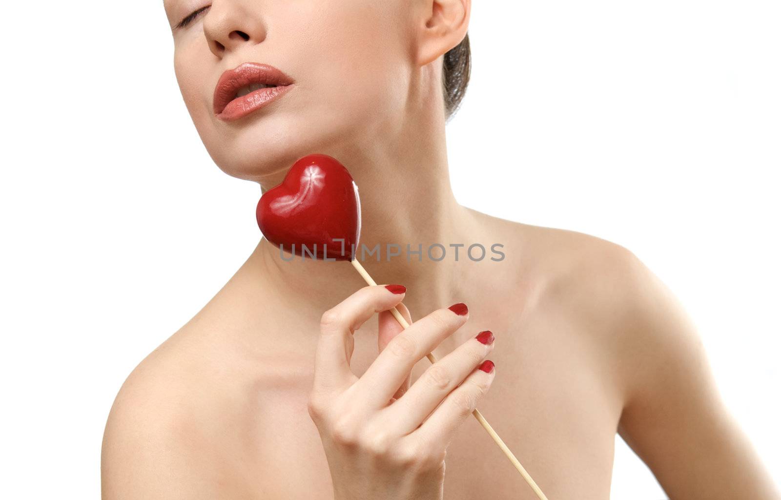 Young woman showing heart shaped candy. Face closeup. Isolated on white background by kirs-ua