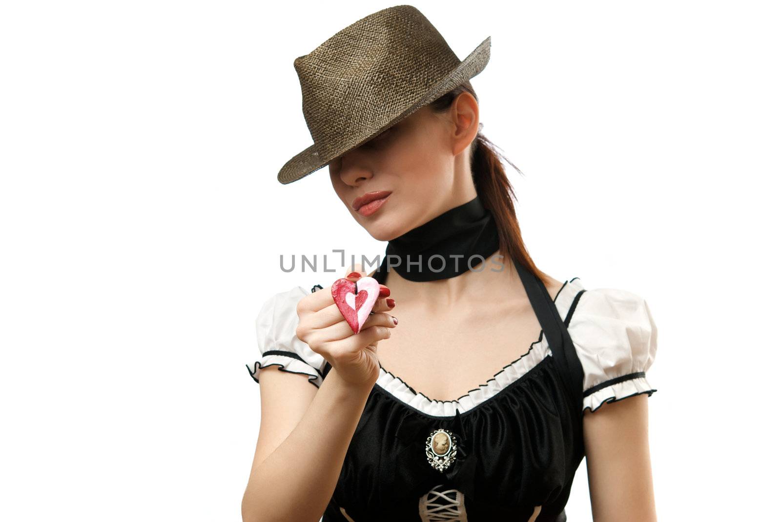 Young woman wearing hat showing heart shaped pendent. Isolated on white background