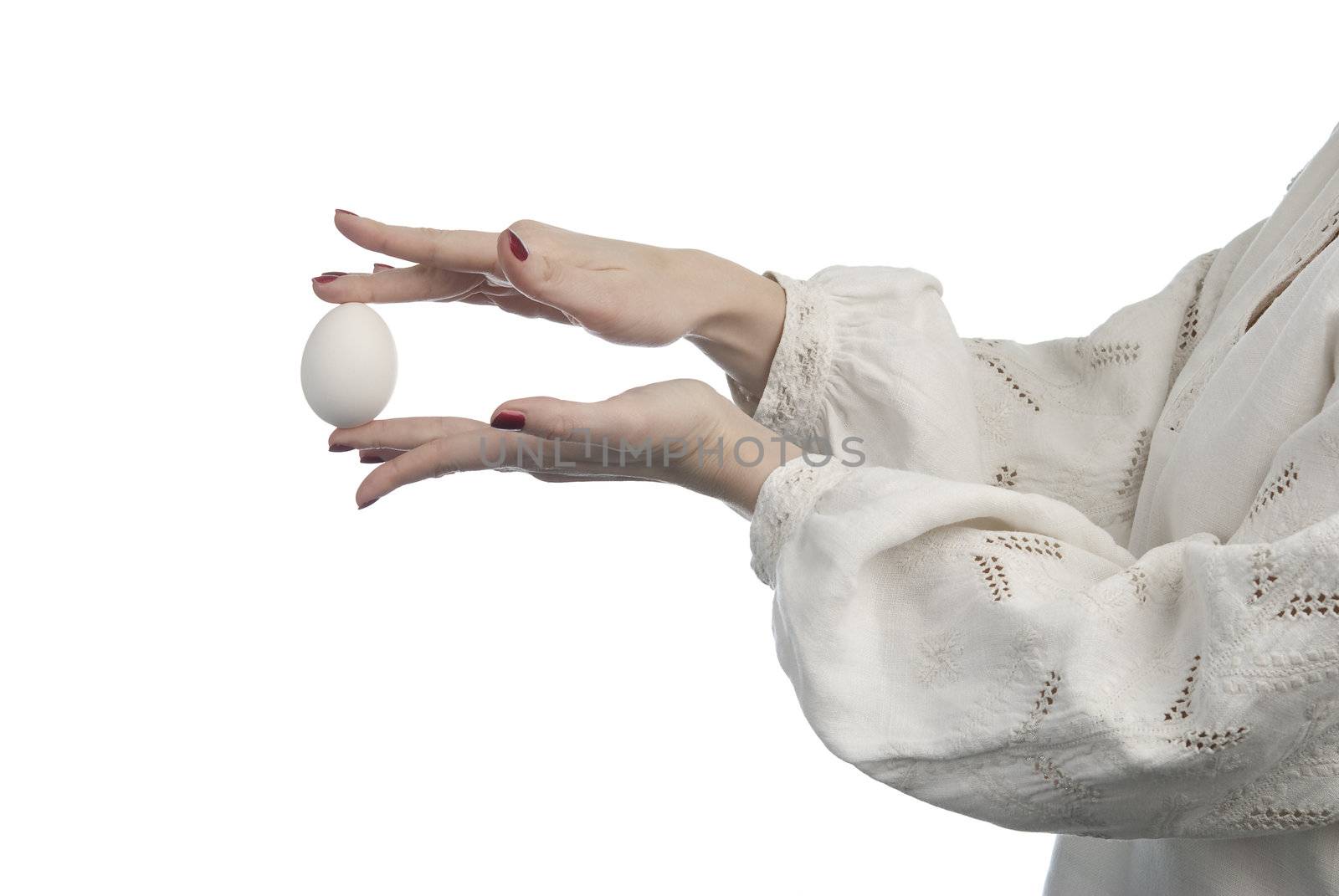 Woman's hands holding the egg. Traditional Ukrainian dress. Isolated on white