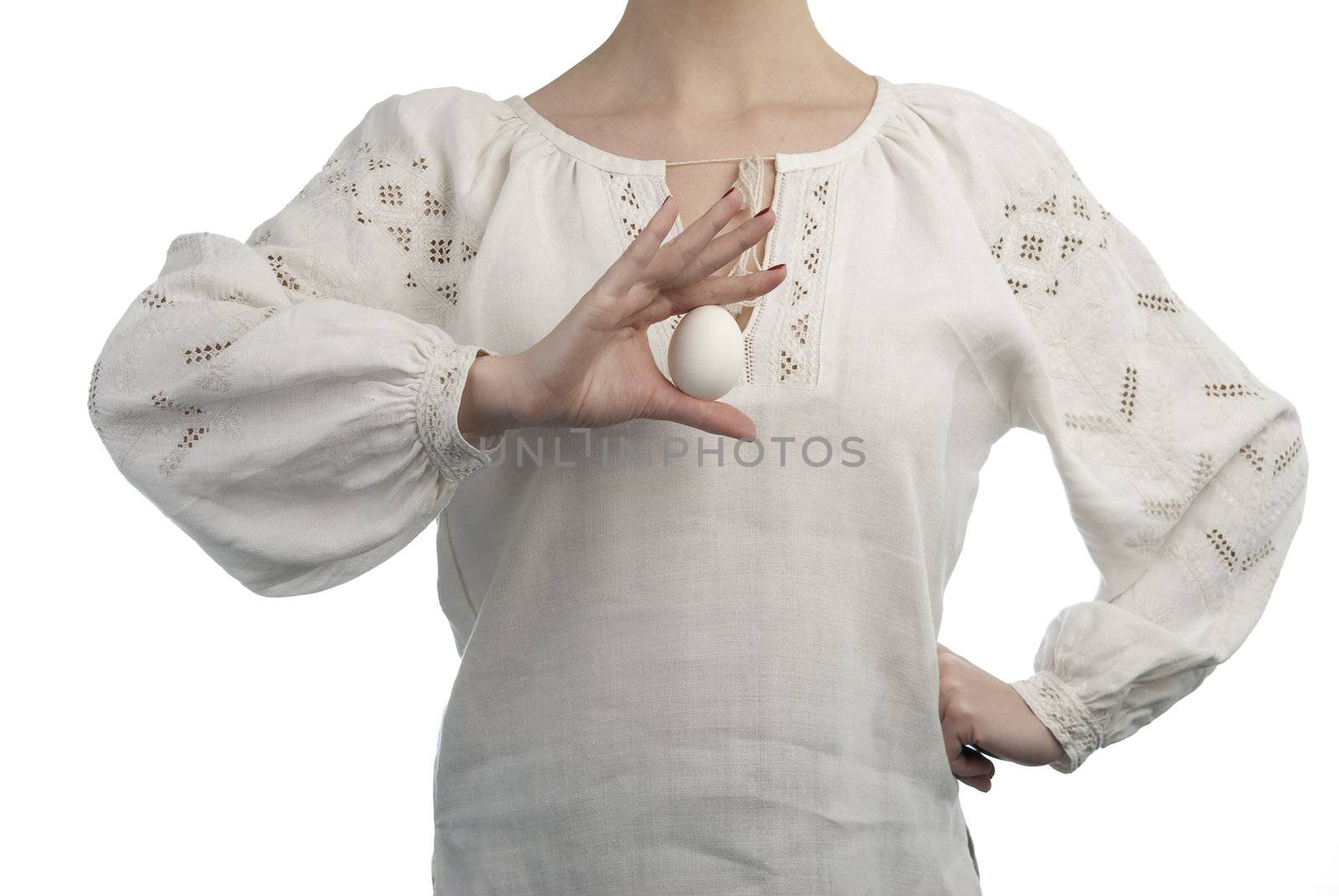 Woman's hand holding the egg. Traditional Ukrainian dress. Isolated on white