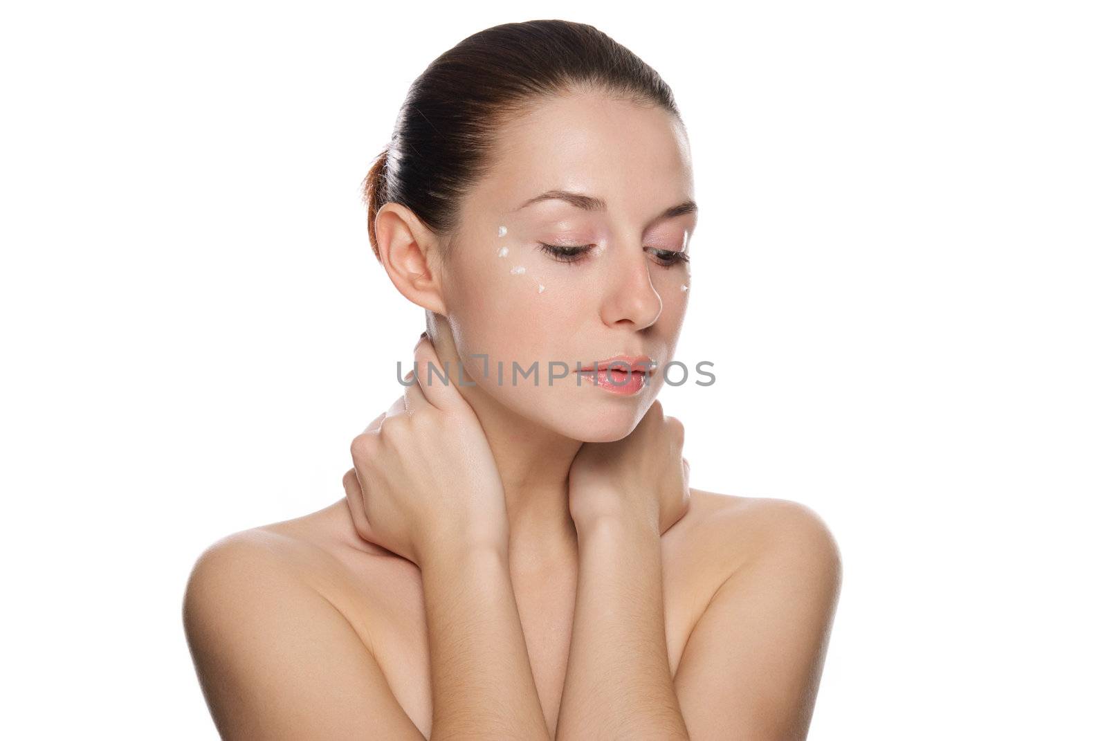 Beautiful sexy woman applying cosmetic cream on skin near eyes. Isolated on white background