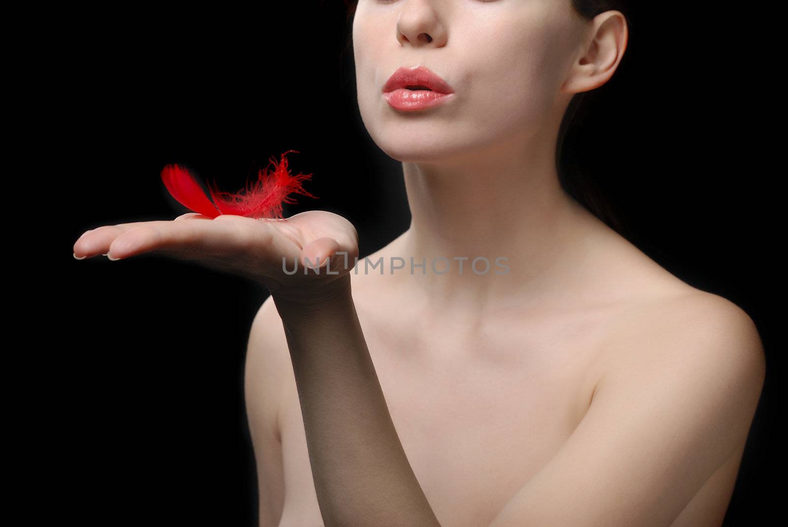 Young beautiful woman topless holding a plume