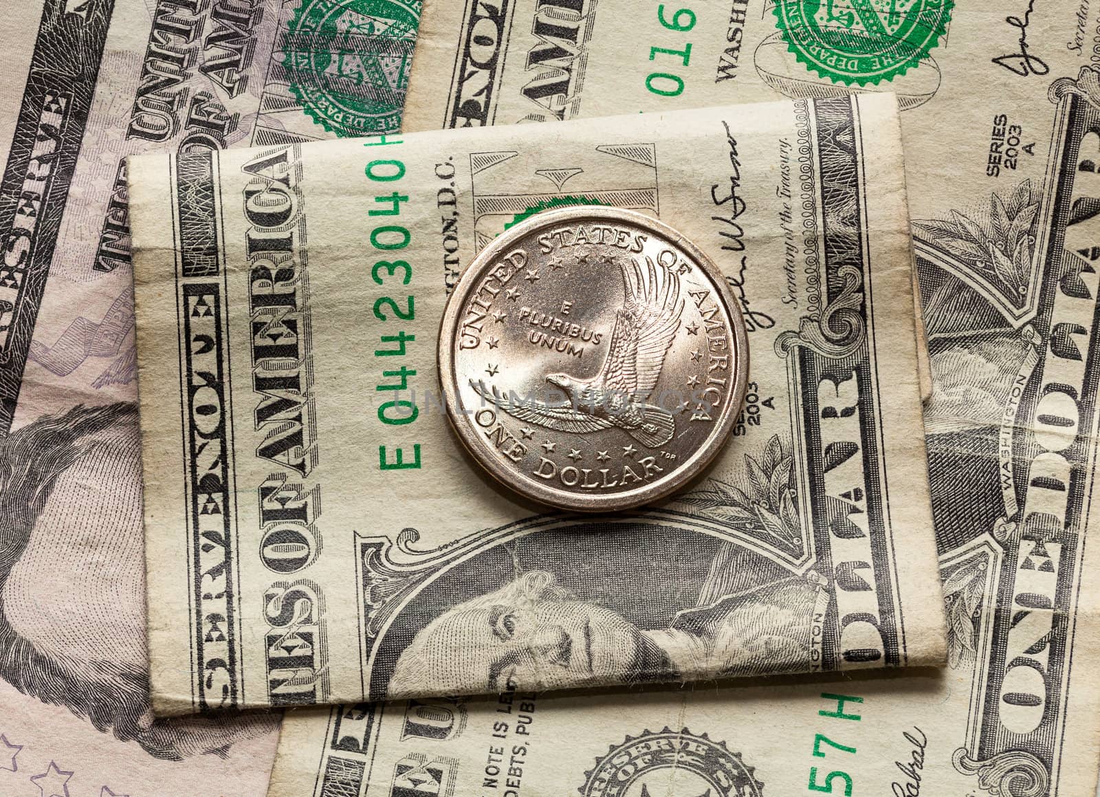 Contrast of the US dollar and half dollar coin with a worn paper bill