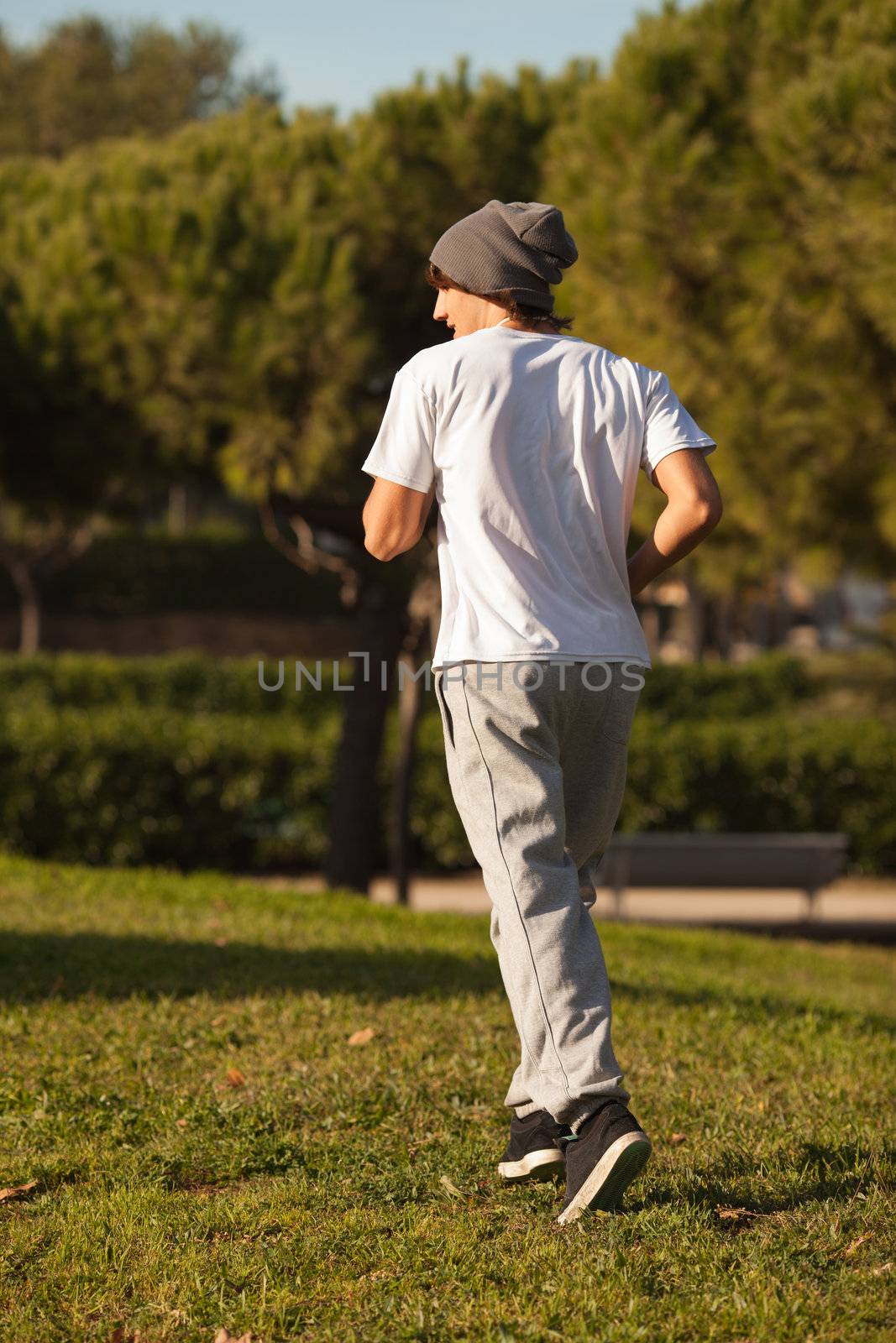 young handsome man jogging in public park