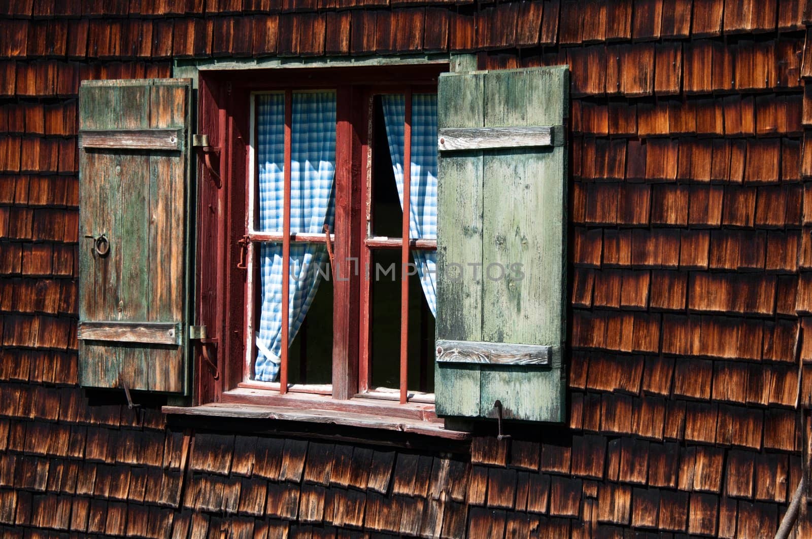 window of idyllic wood panelled alpine cottage in bavarian alps