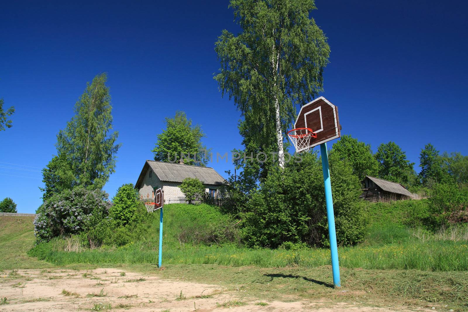 basketball ring on rural atheletic stadium by basel101658