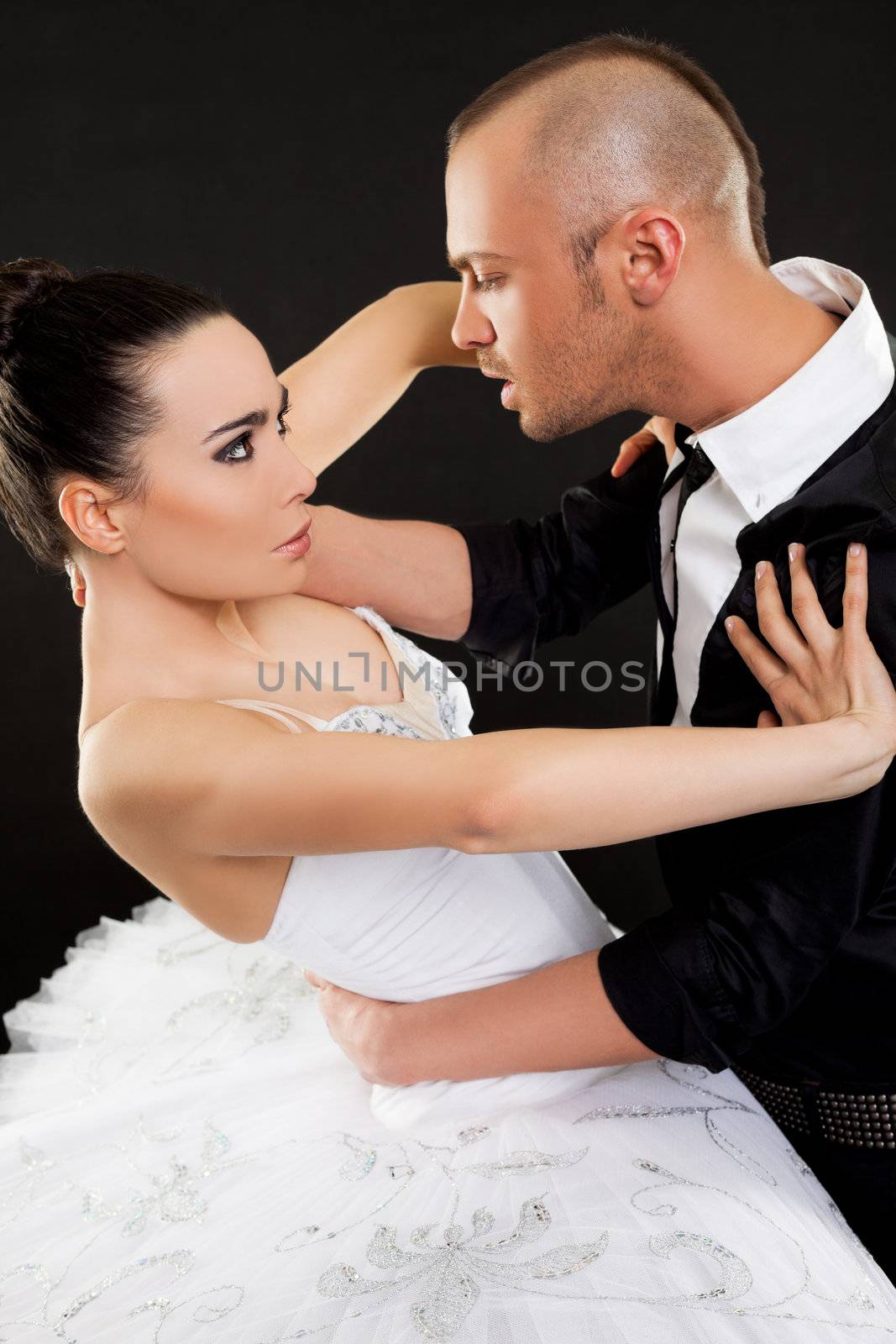 Young male agressively trying to hug beautiful ballerina