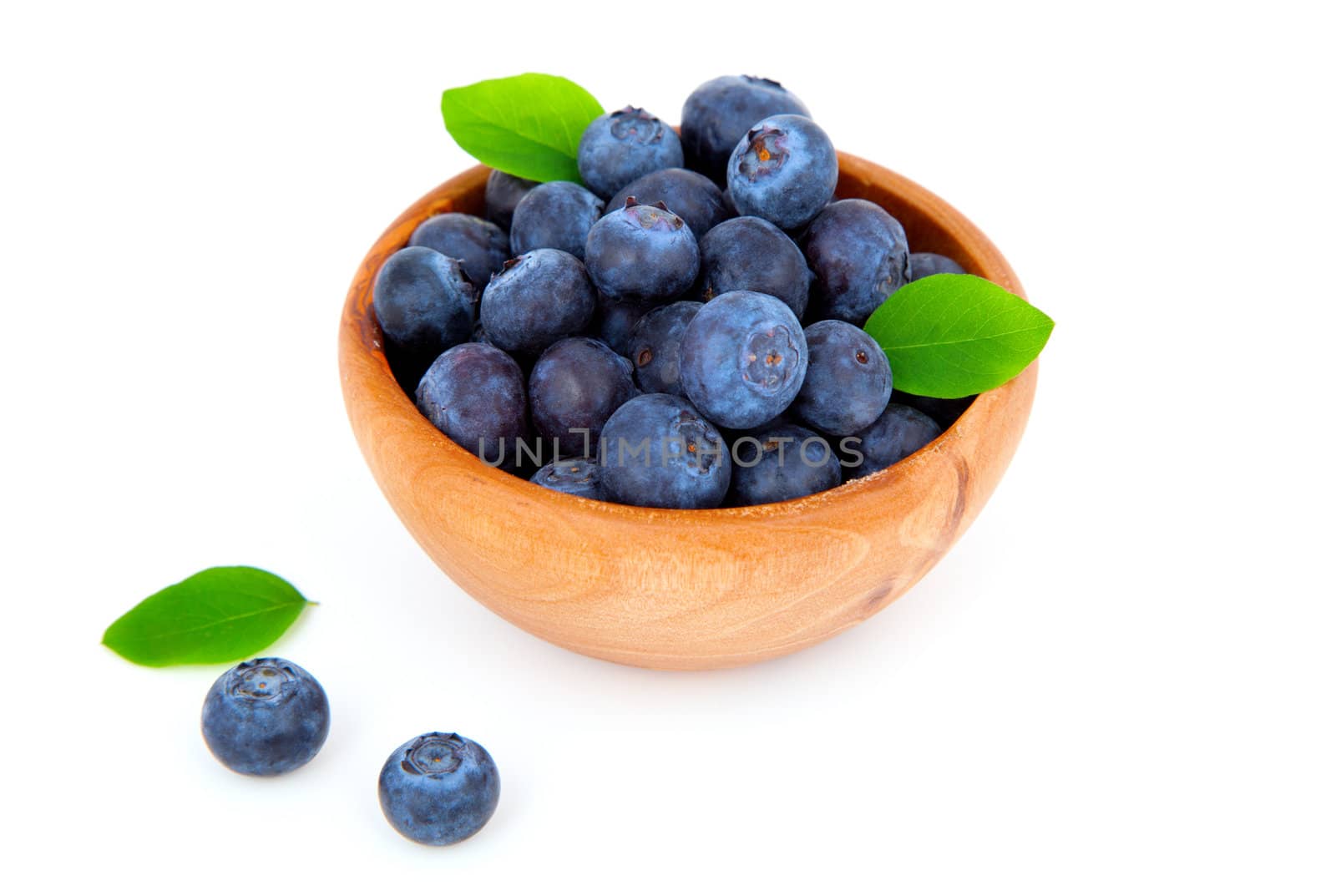 fresh blueberry in a wooden bowl with leaves, over a white background.