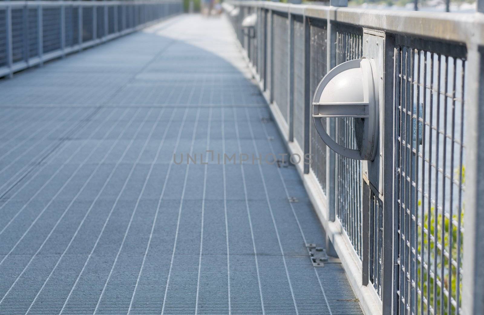 Diminishing steel walkway with modern lighting and soft focus backgroun