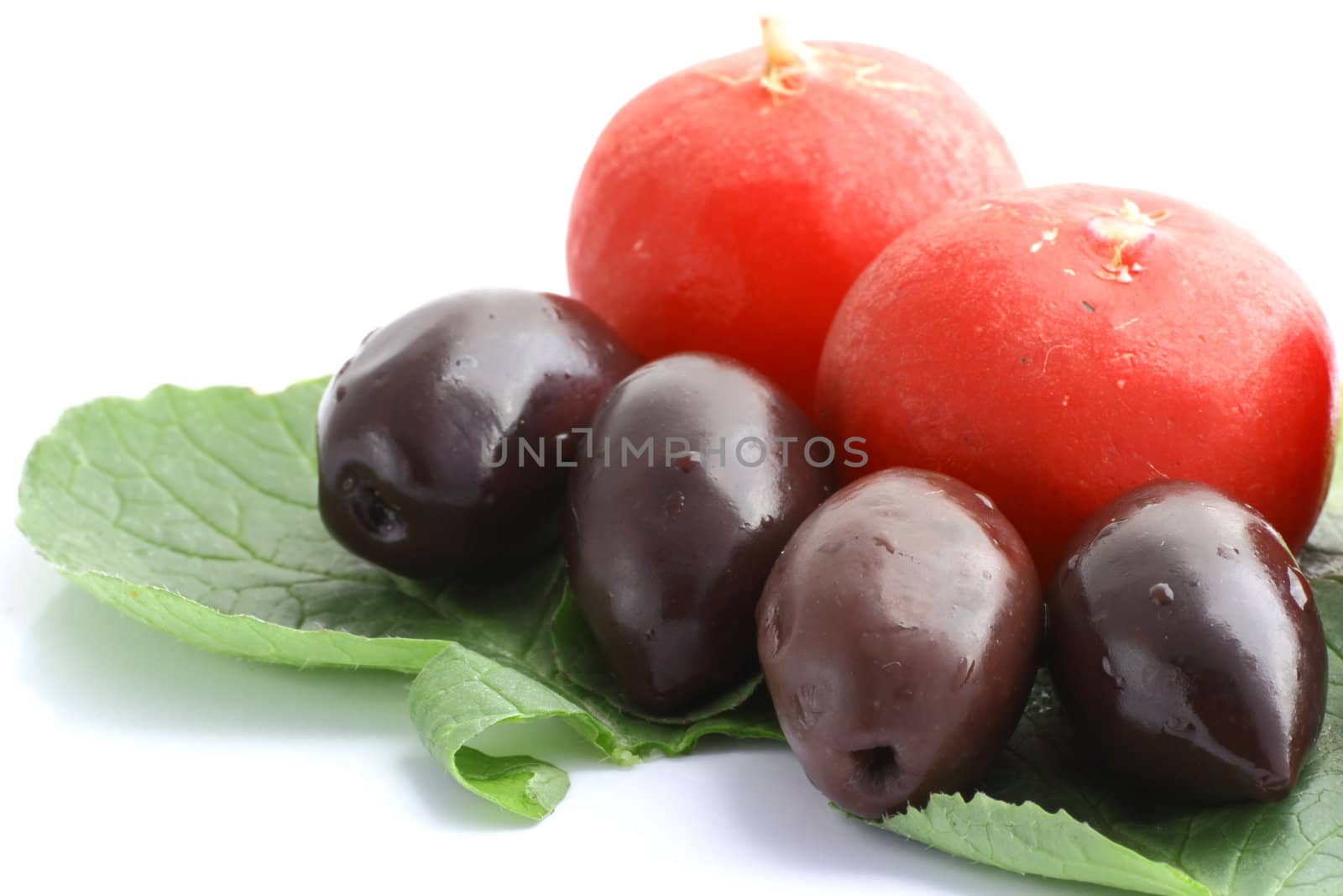 olives and radishes on a green leaf