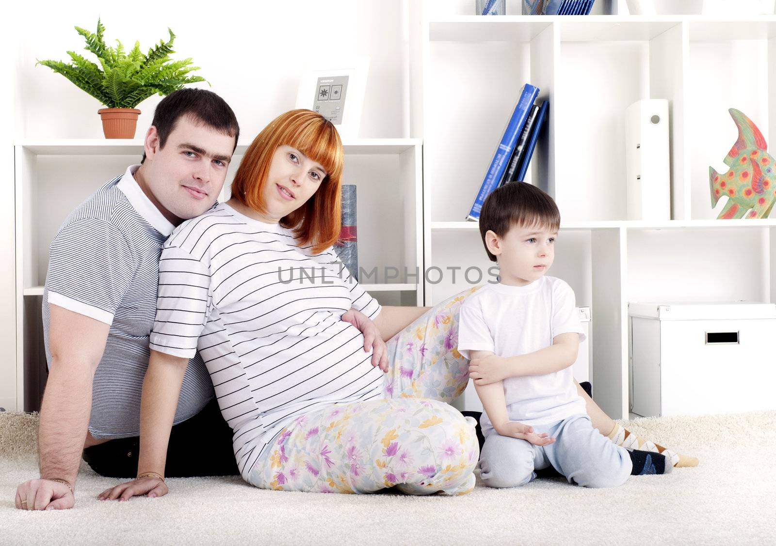 portrait of a pregnant woman, father and his son, at home
