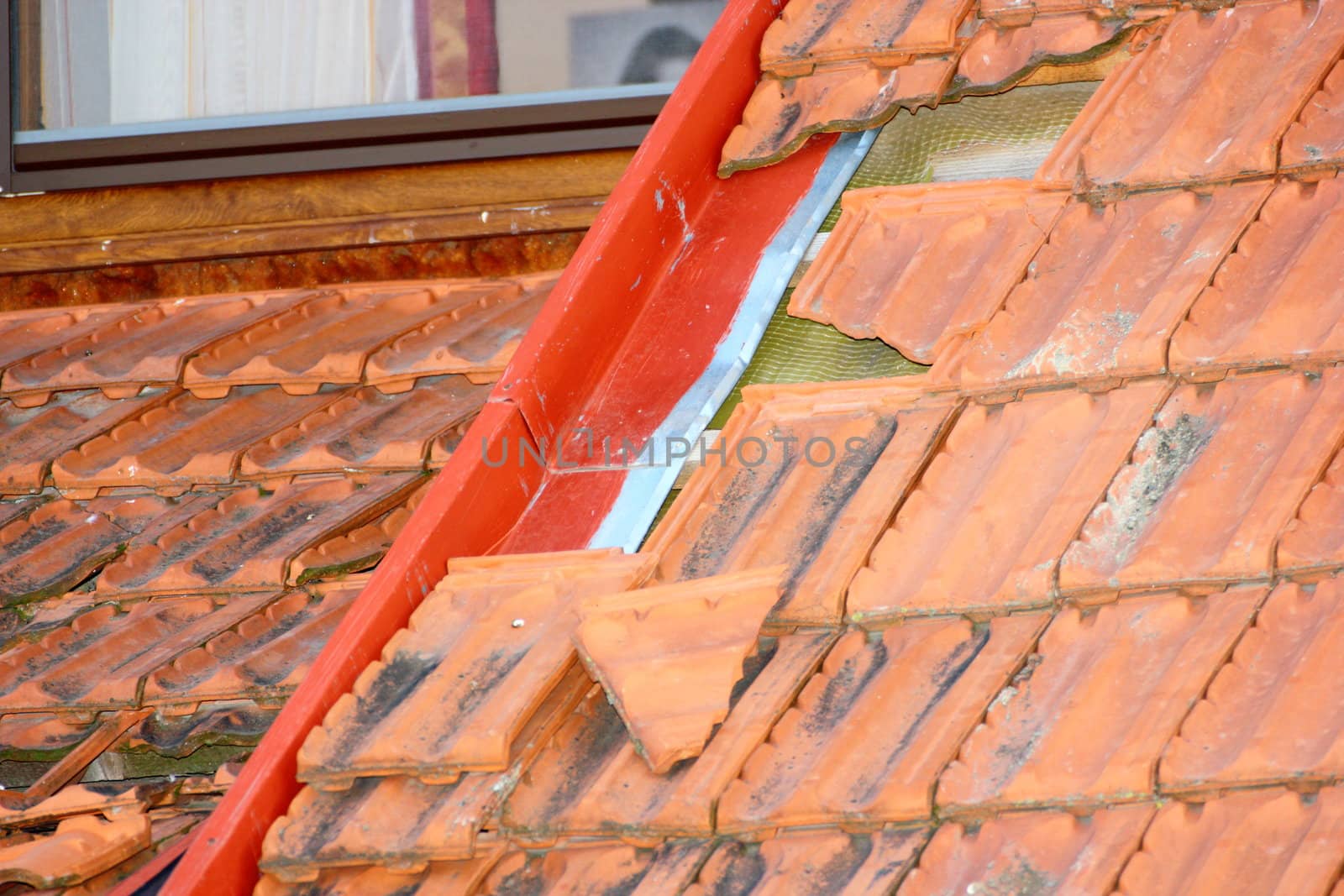 damaged tiles on roof after a heavy summer storm
