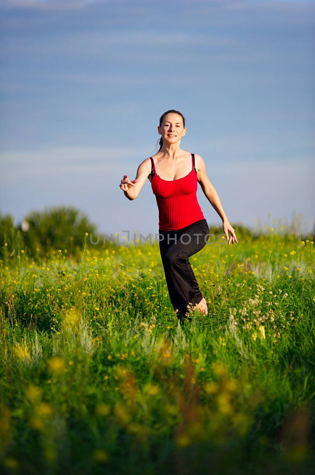 Sport woman running on a sunset field