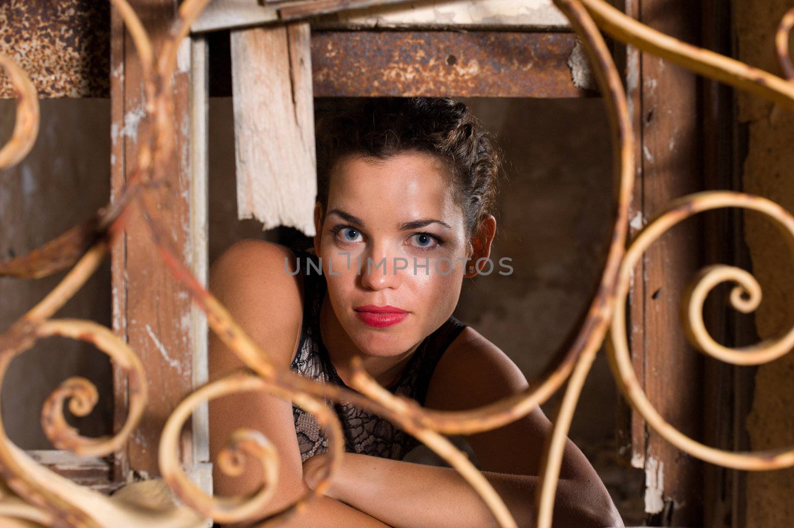 Portrait of a woman looking out of the window of a ruin