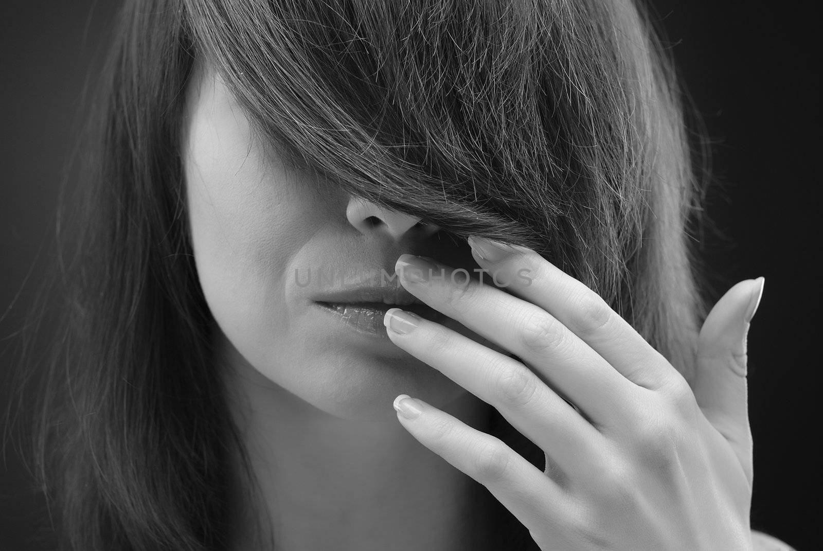 Black and white portrait of young beautiful woman touching her lips