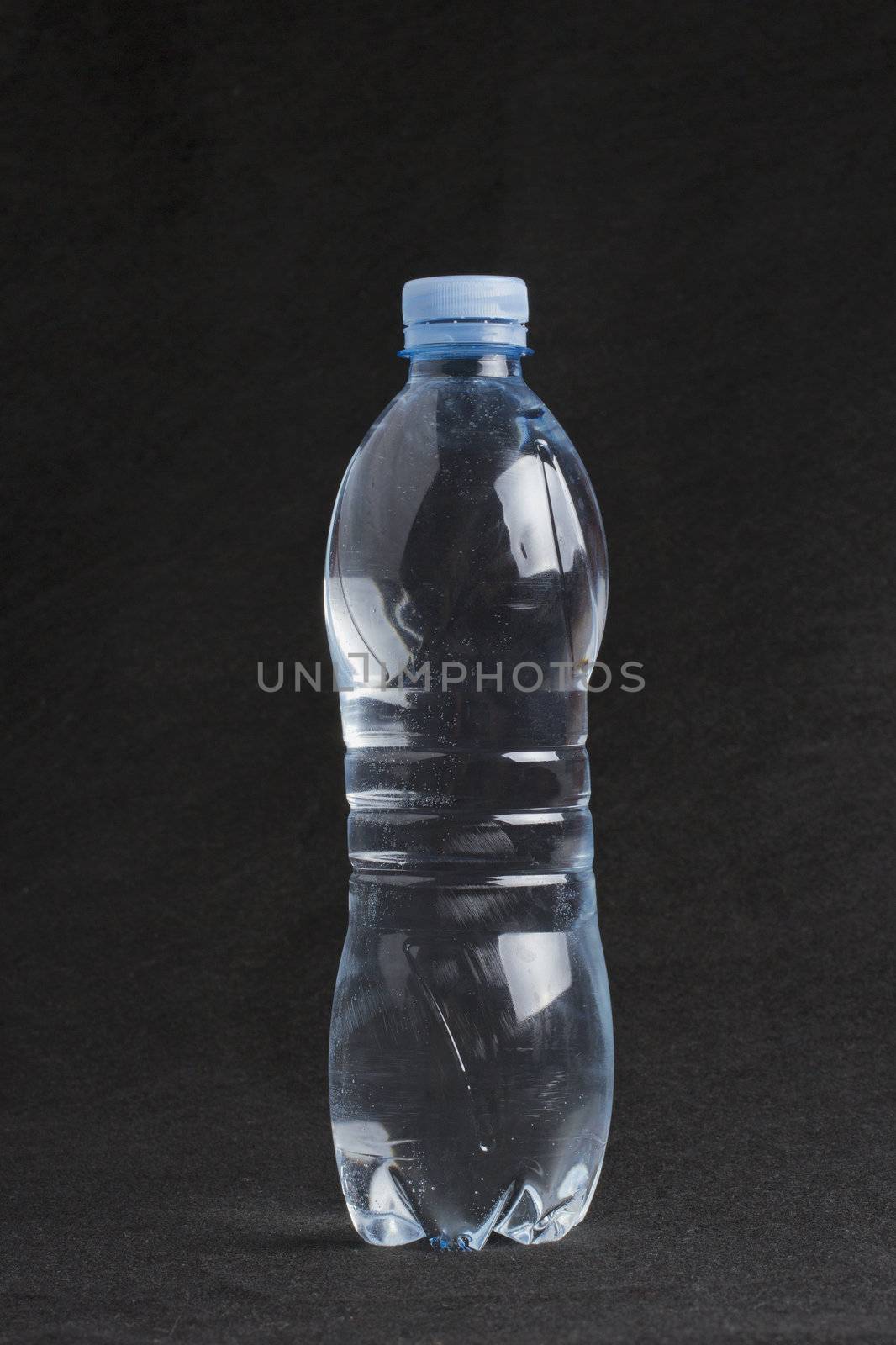 Water plastic blue bottle over black bacground